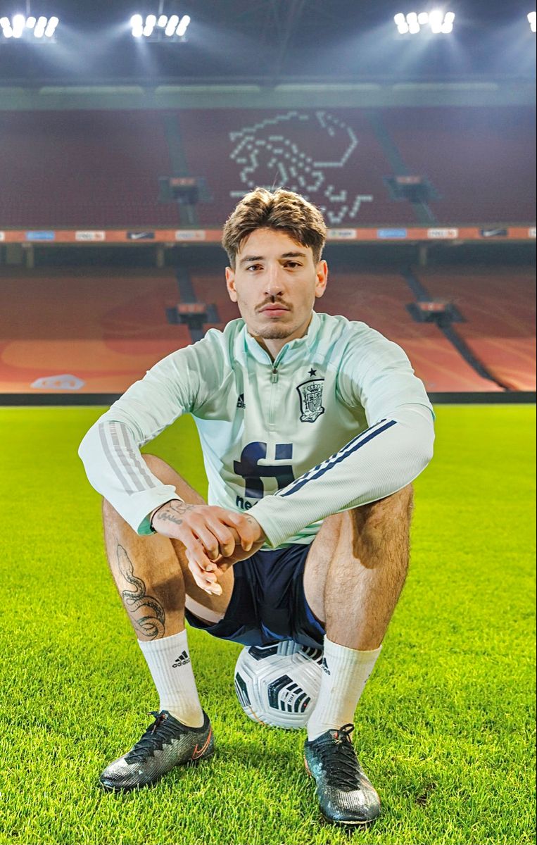 Spanish Football Player Crouching on Stadium Pitch