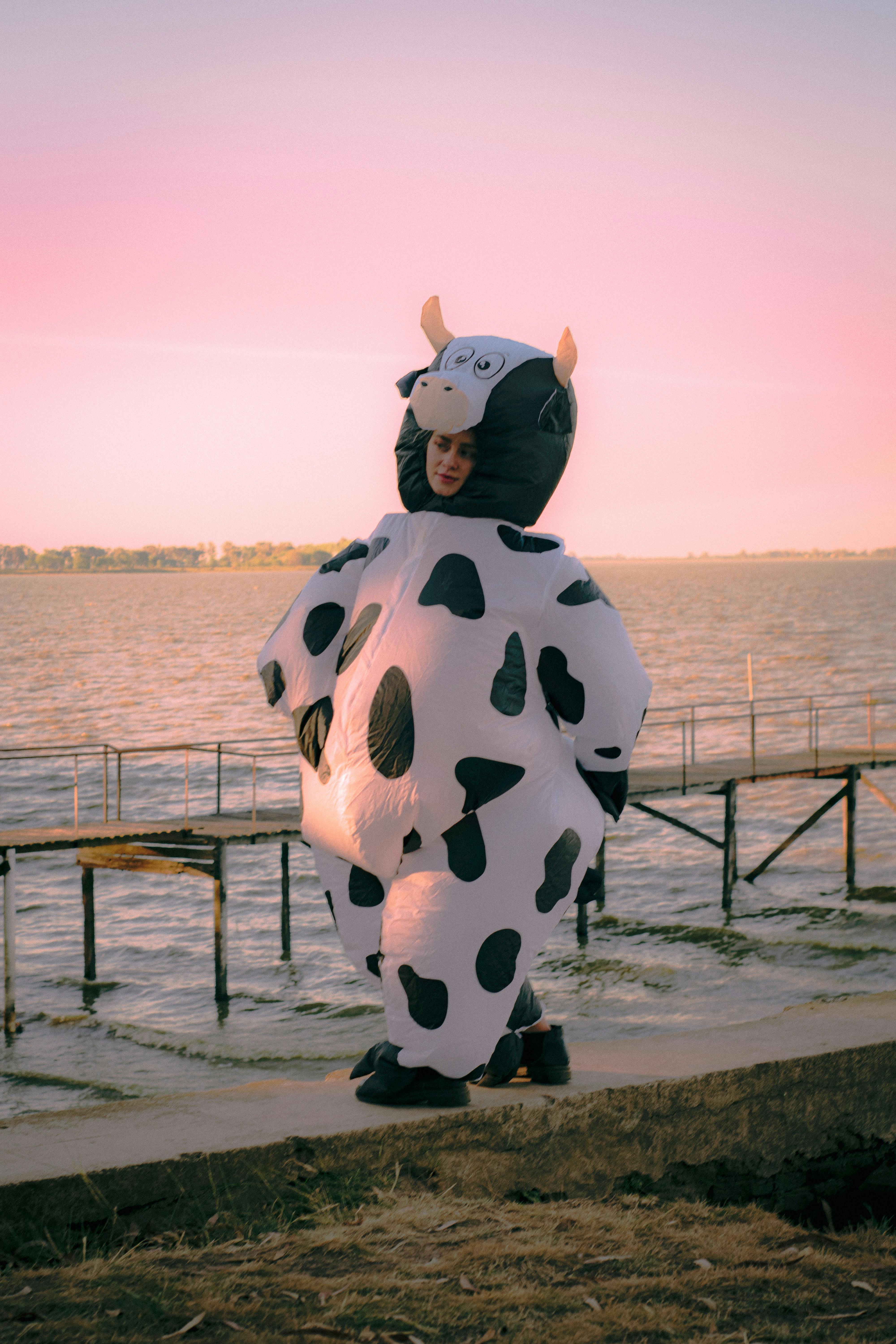 Person in Cow Costume by Lake at Sunset