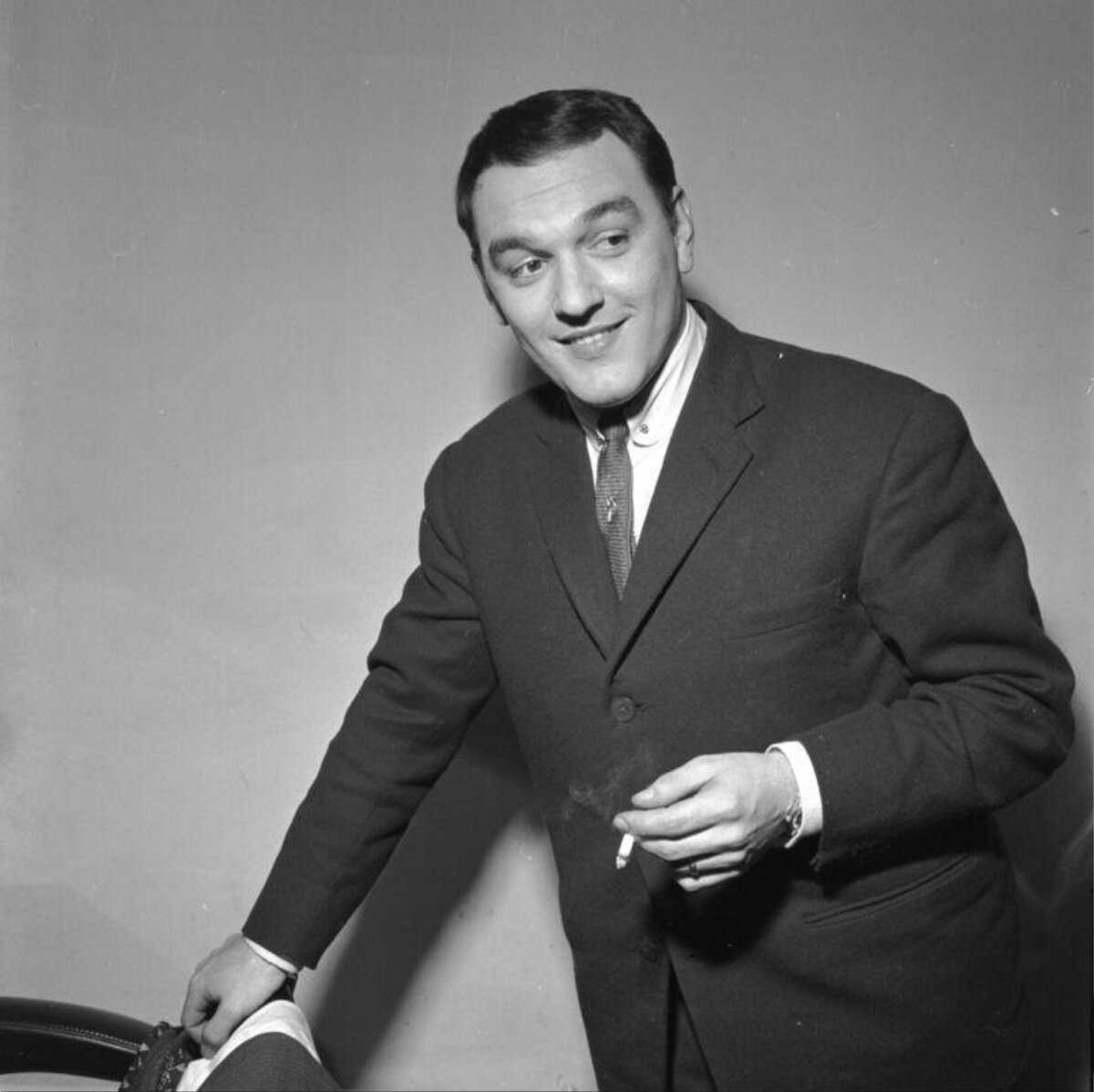 Smiling Man in Suit Holding Cigarette