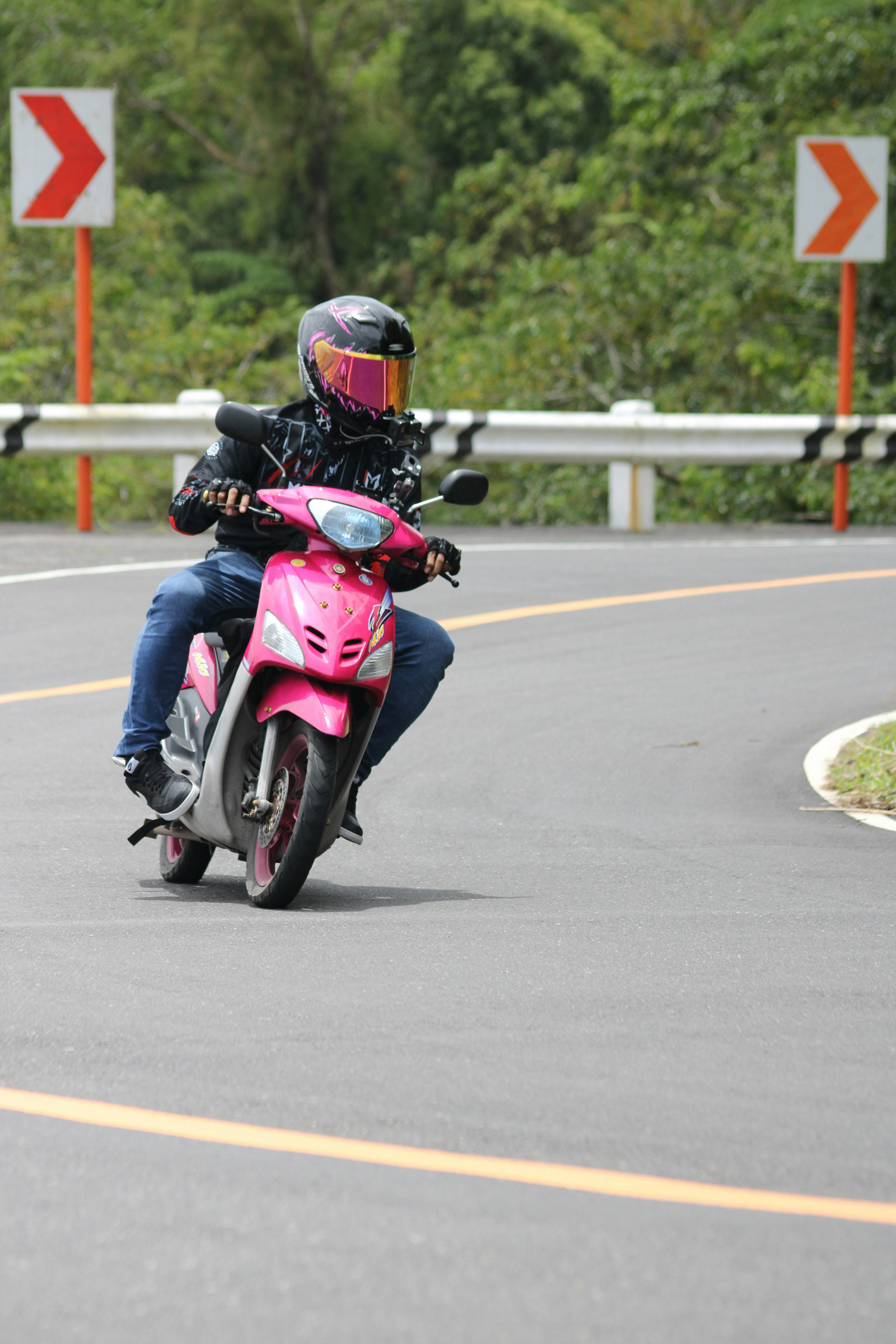 Rider on Pink Scooter on Curved Road