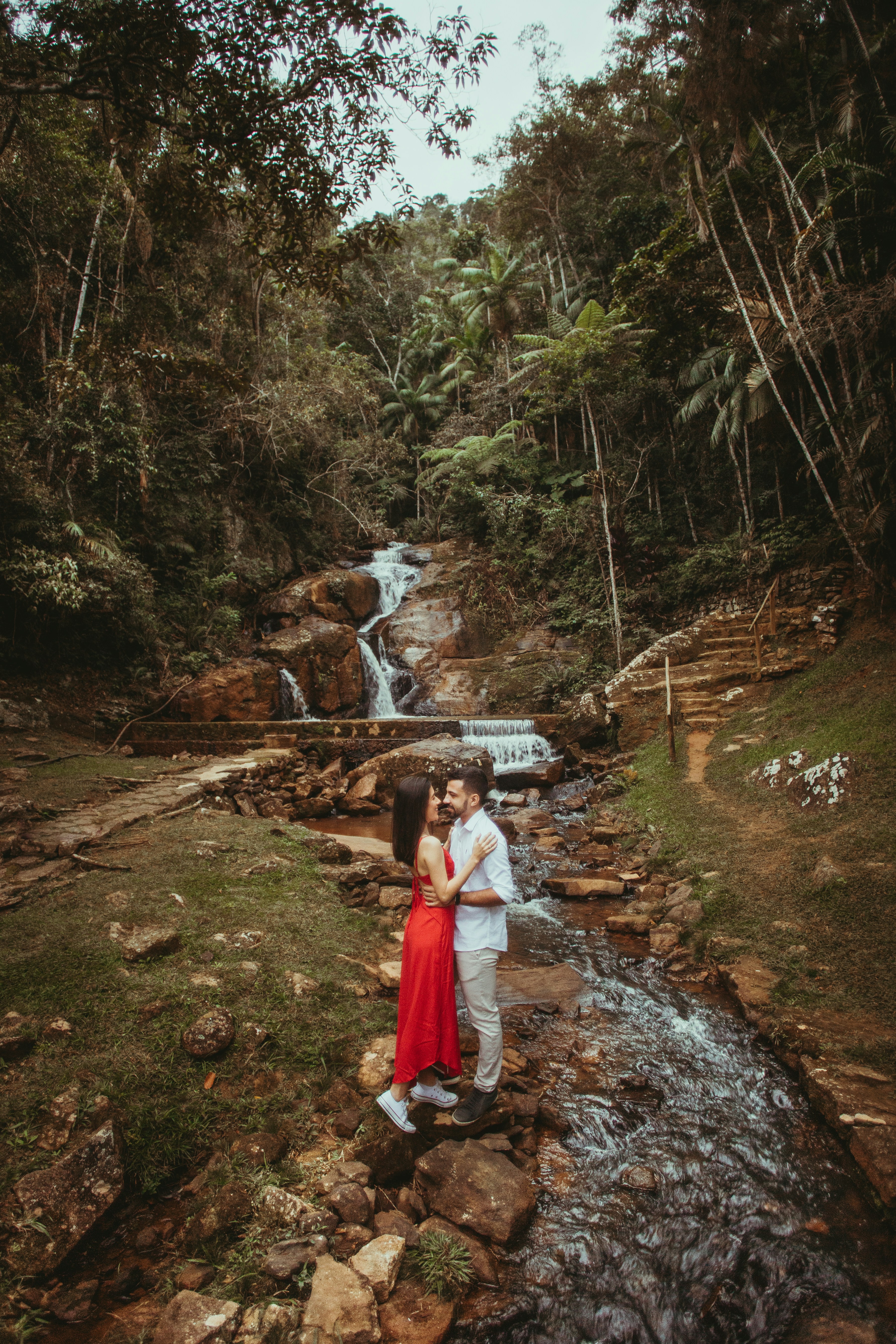 Couple Embracing By Forest Waterfall