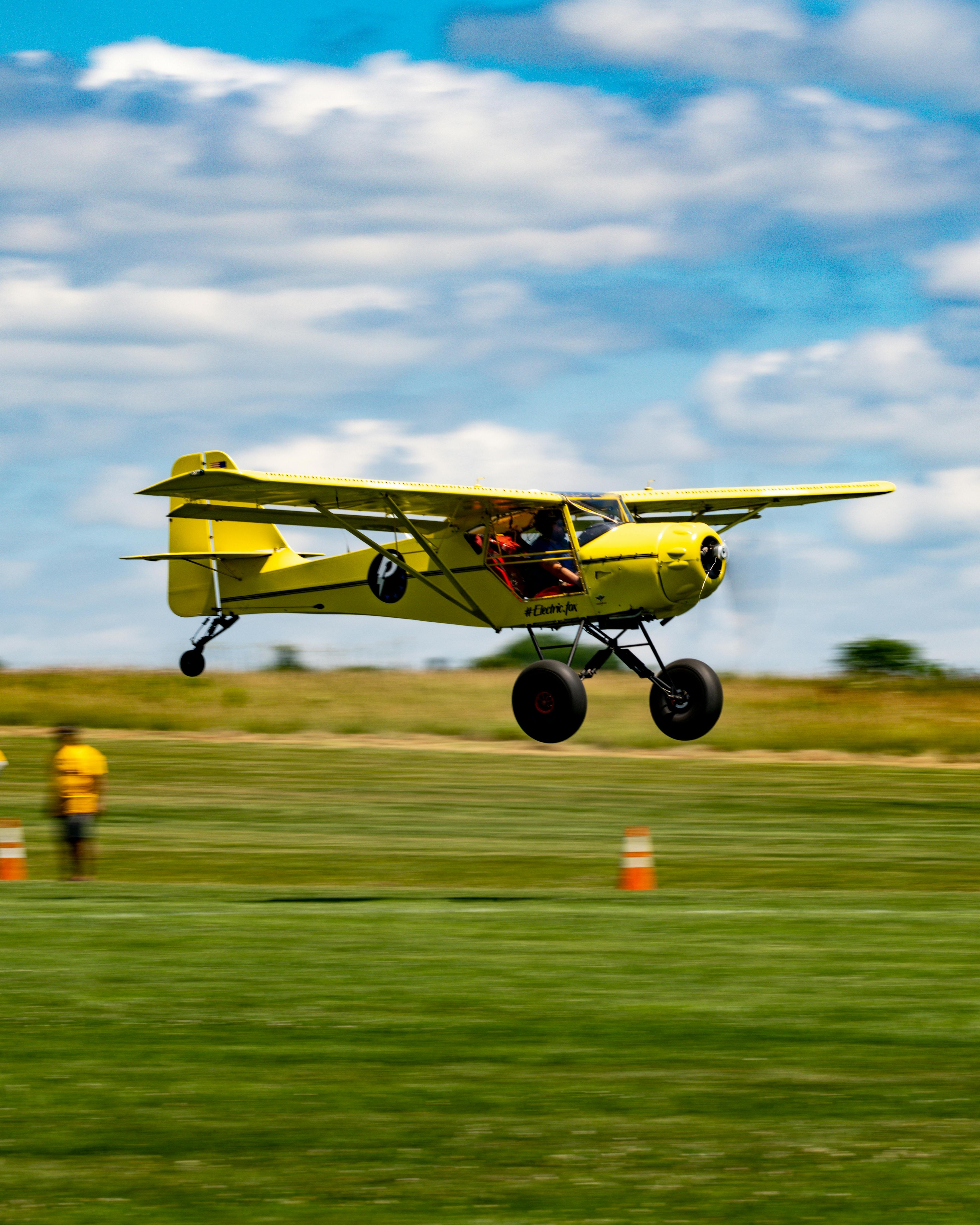 Yellow Small Plane Low Flying Over Airfield