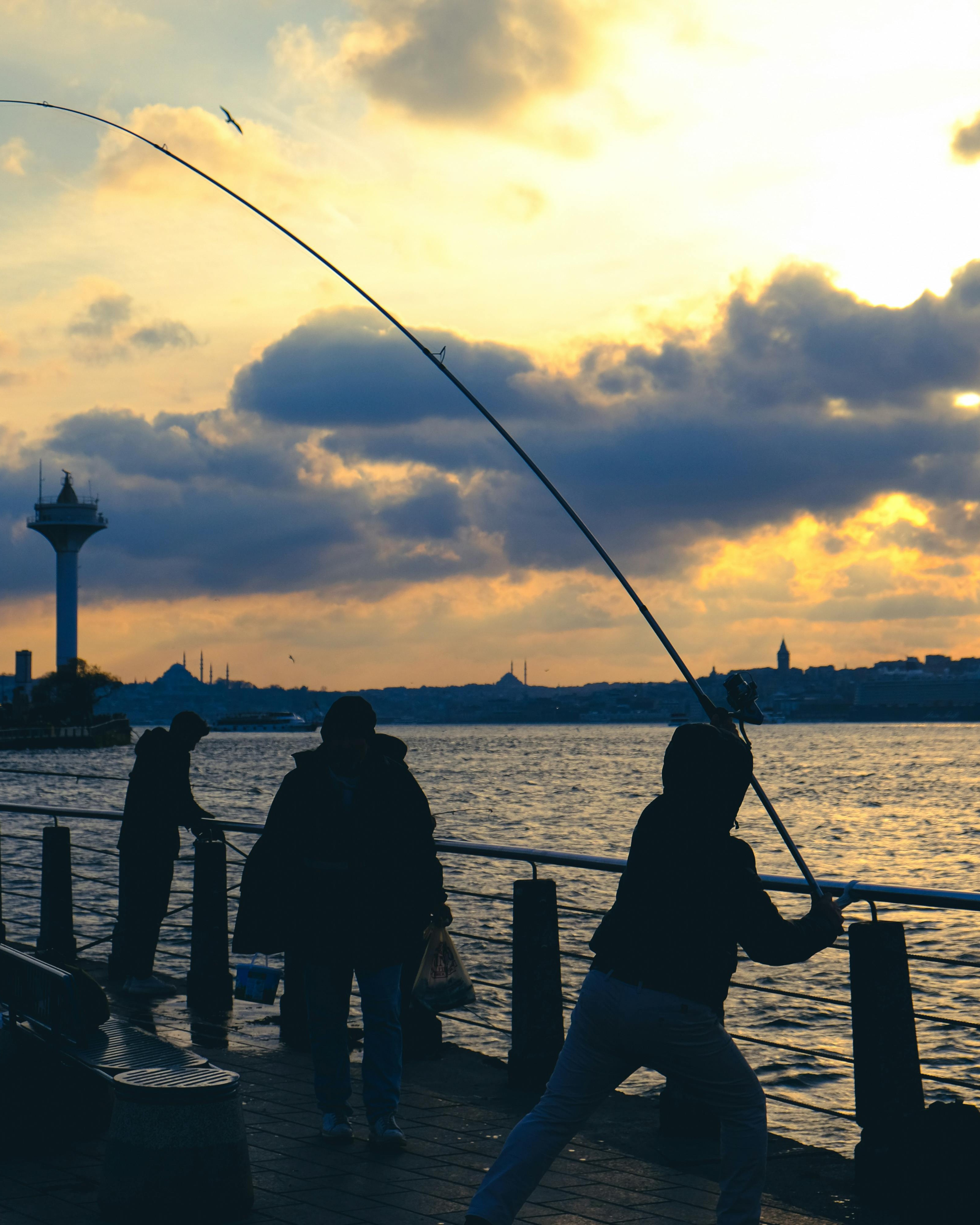 Anglers Fishing at Waterfront Sunset