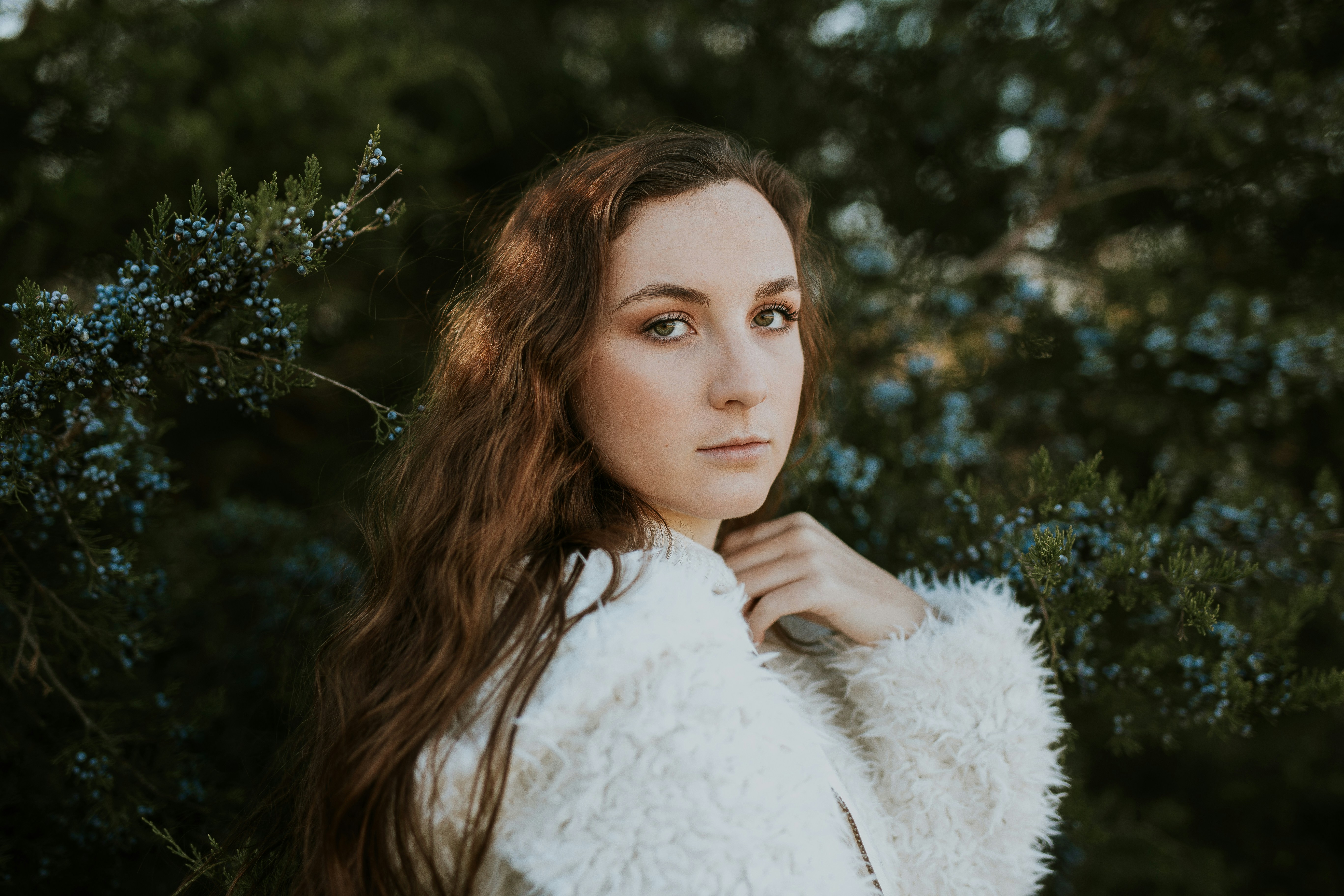 Young Woman Posing Among Juniper Bushes