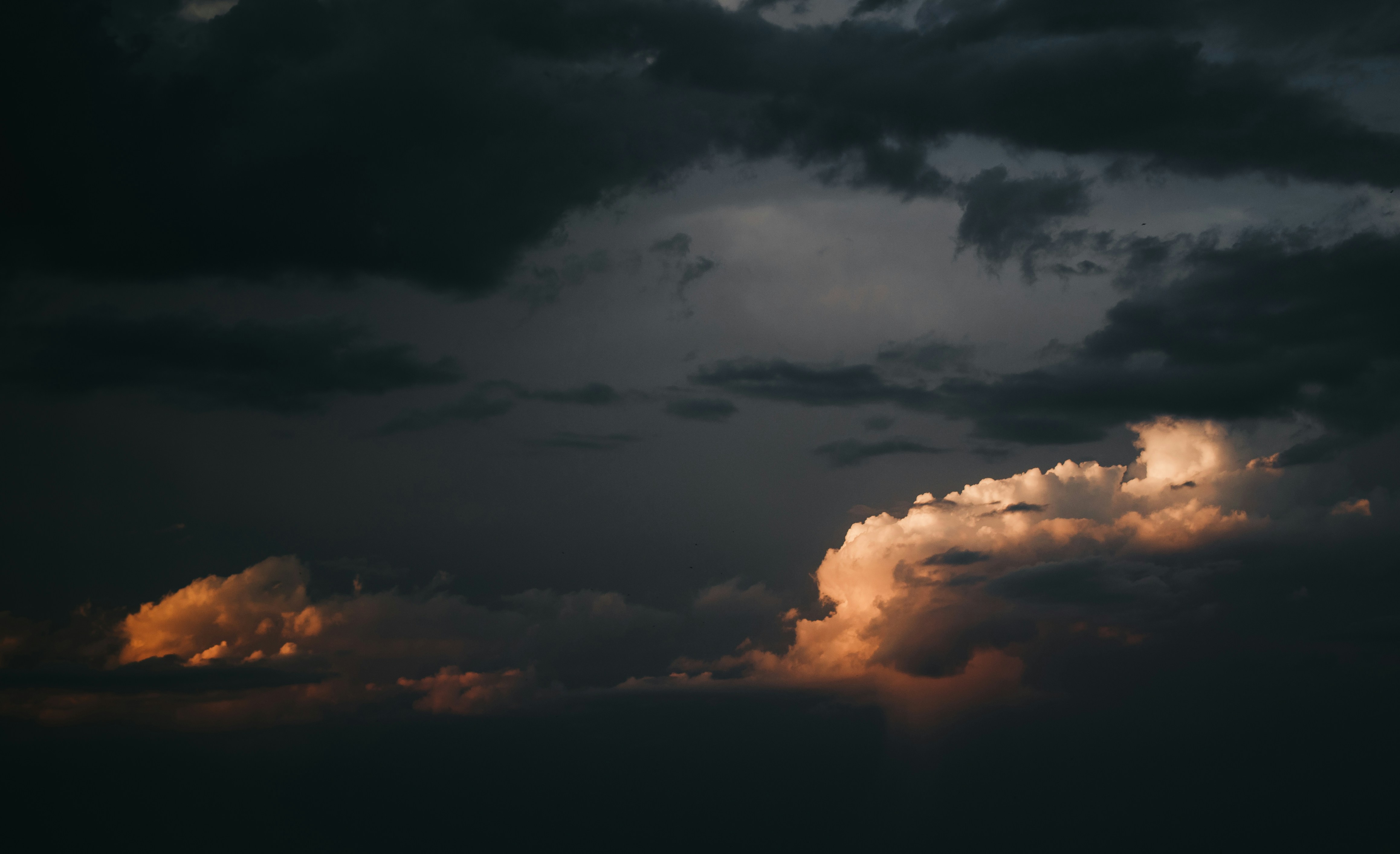 Sunlit Clouds Under Dark Sky