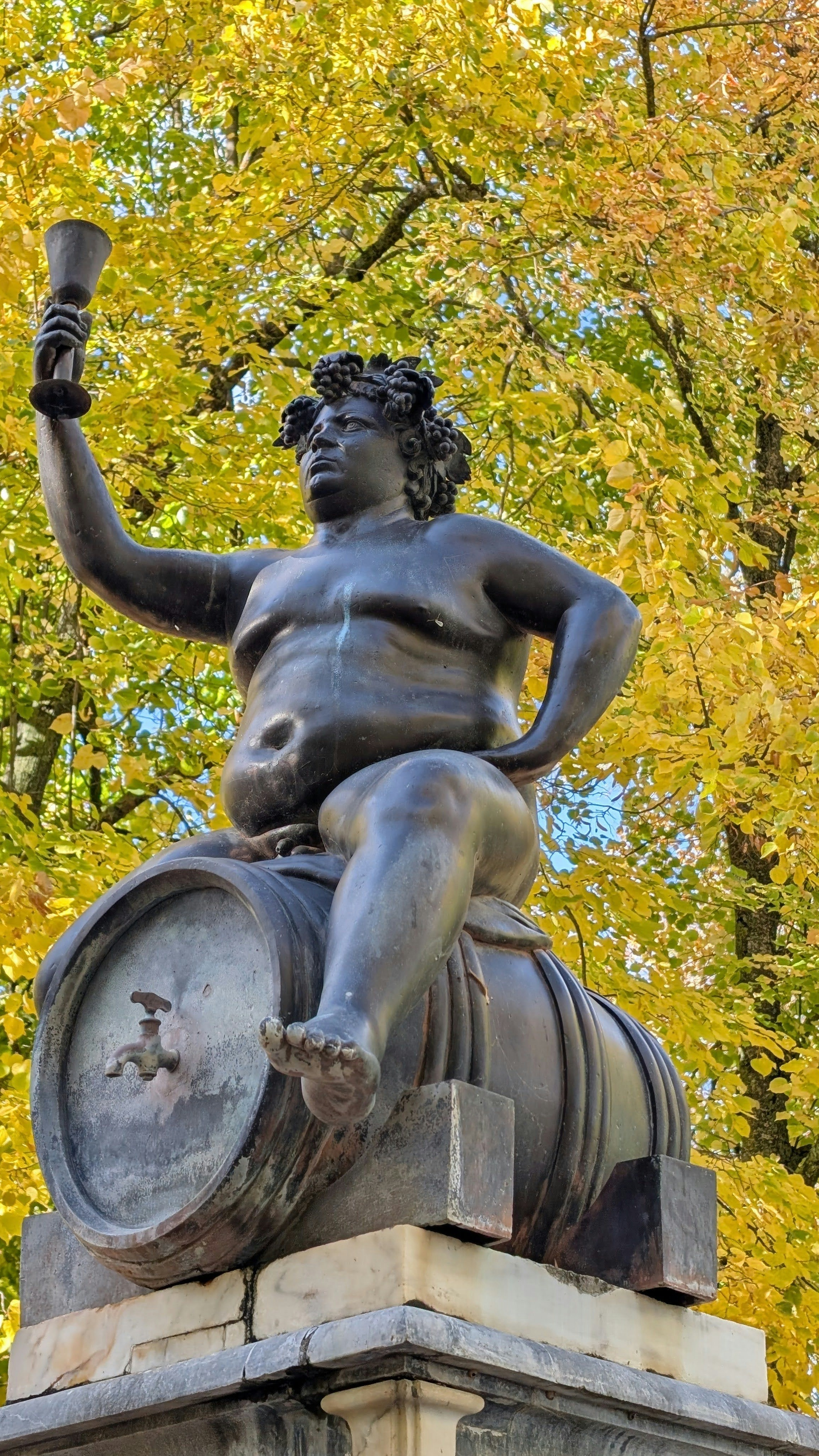 Bacchus Statue on Wine Barrel in Autumn