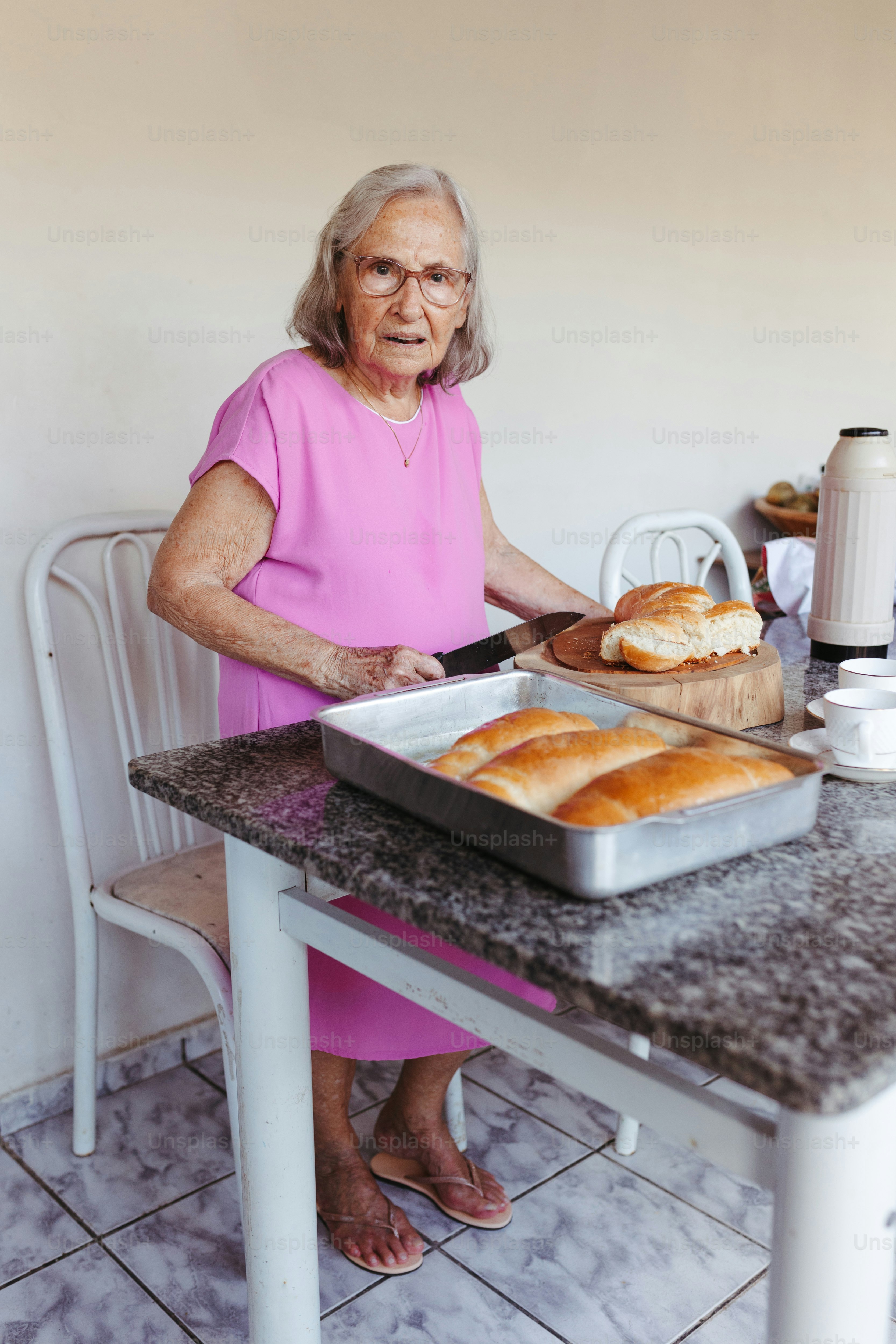 Elderly Woman Cutting Homemade Bread