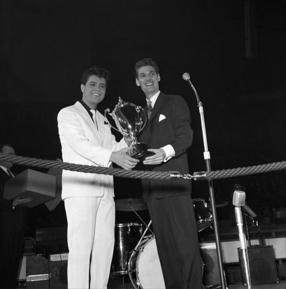 Two Men Holding Championship Trophy on Stage