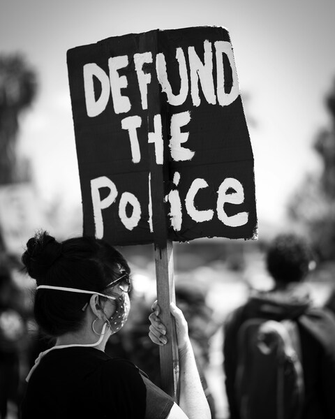 Protestor Holding Defund The Police Sign