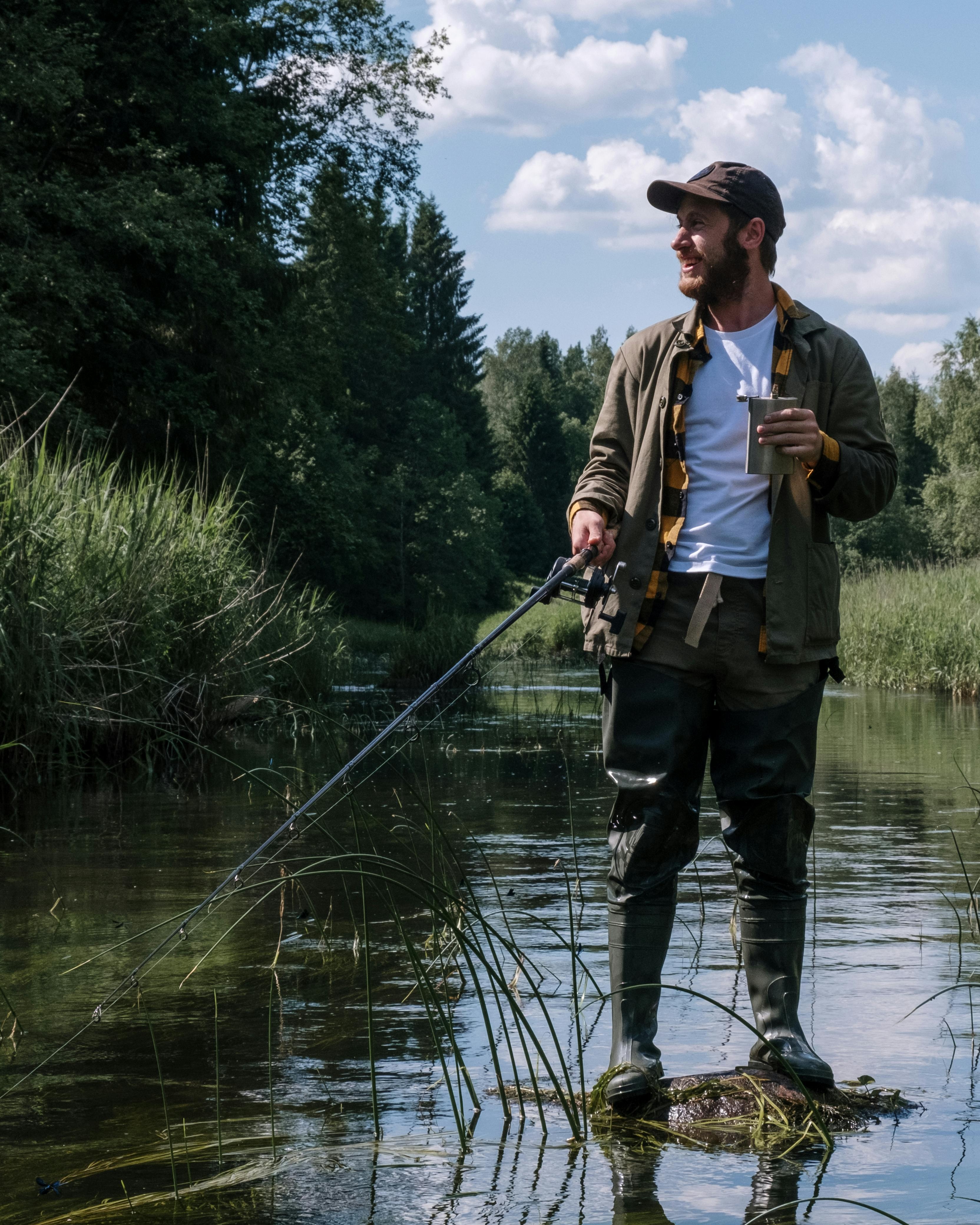 Man Fishing In Shallow River