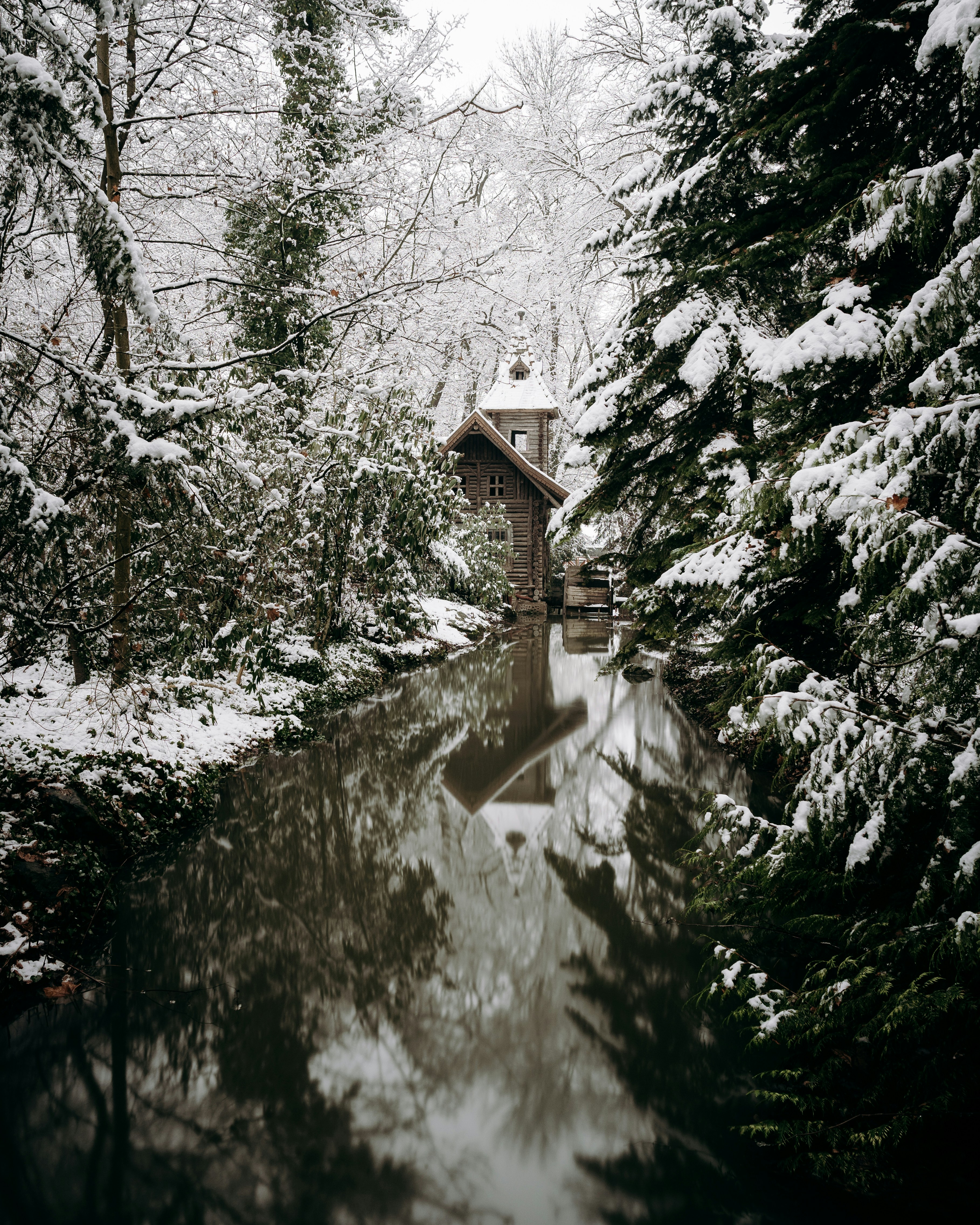 Snowy Log Cabin by Stream
