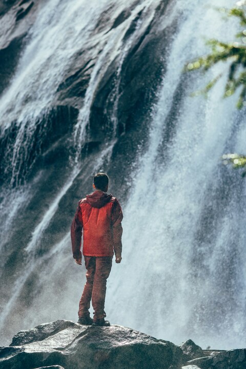 Man Facing Mountain Waterfall
