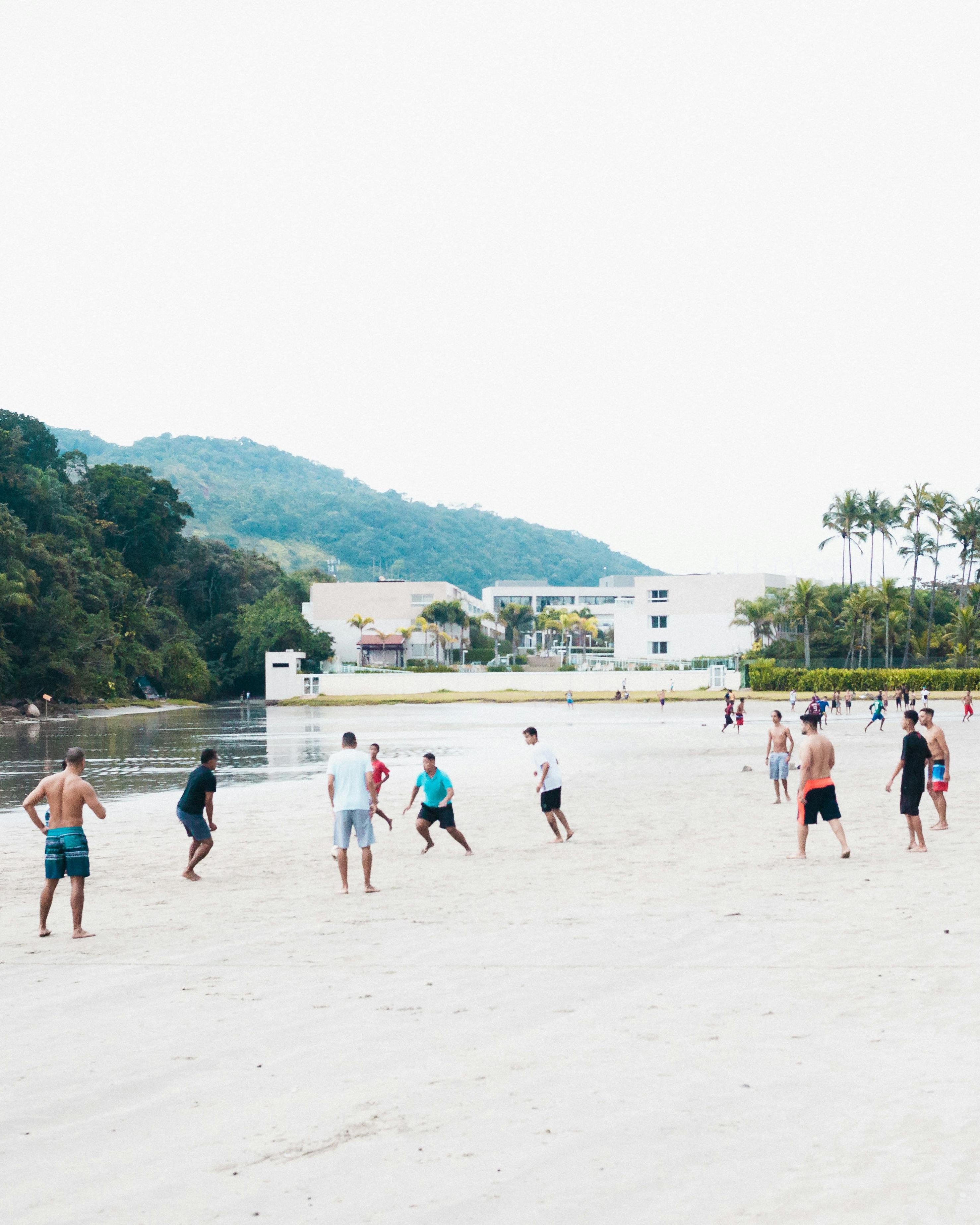 Group Playing Soccer on Beach