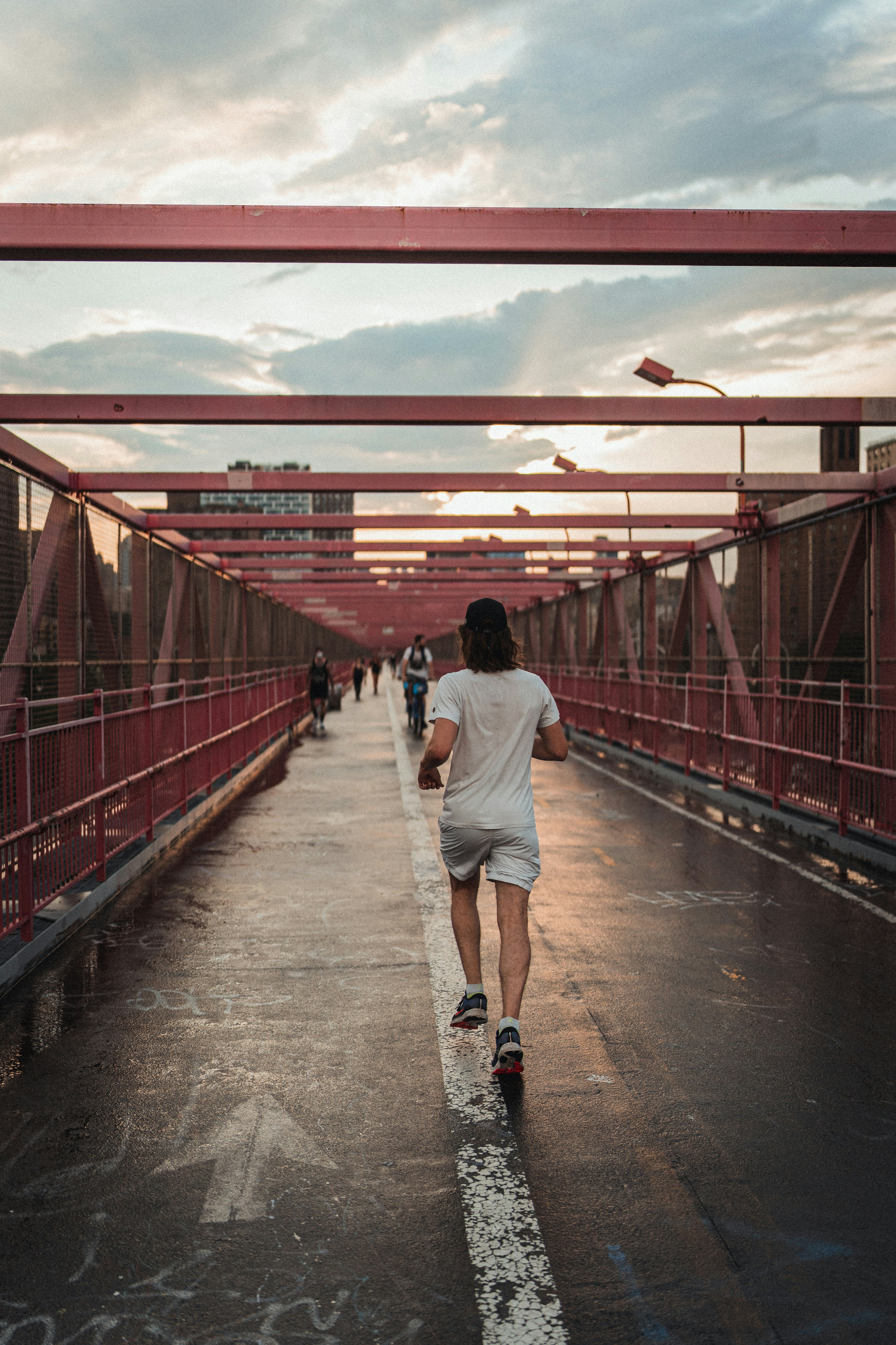 Man Jogging on Red Steel Bridge