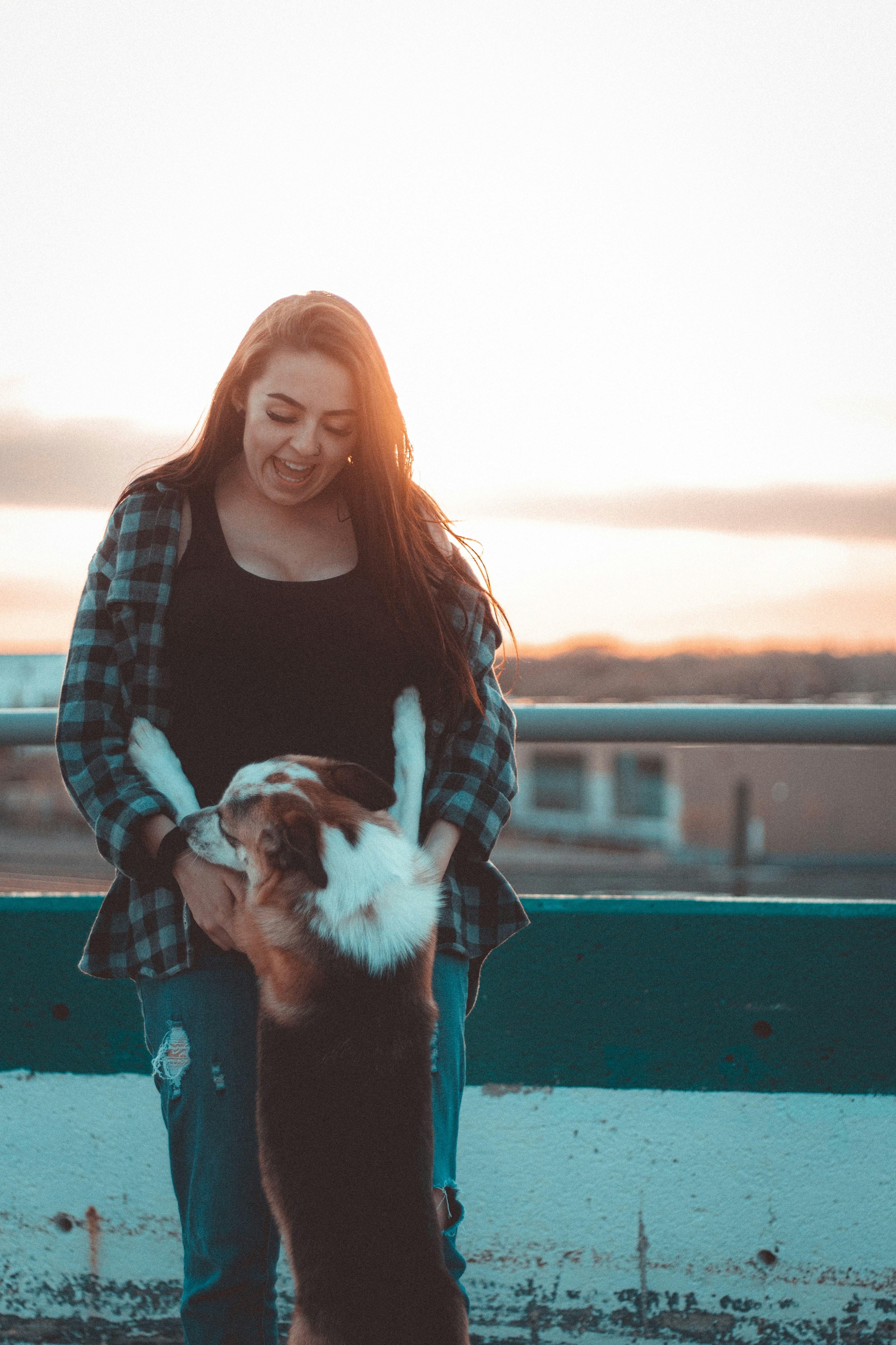 Laughing Woman With Dog At Sunset
