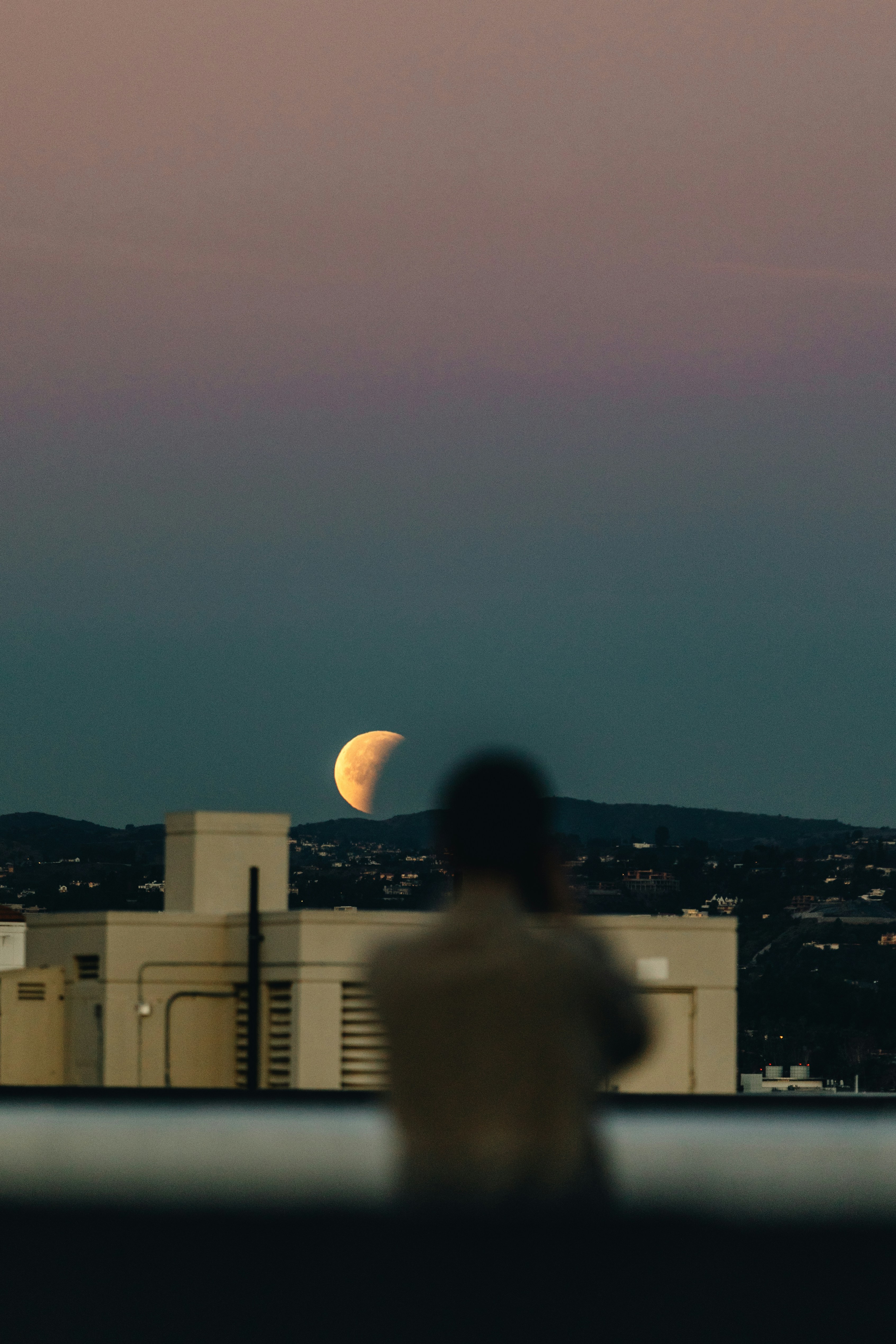 Watching Partial Moon From City Rooftop
