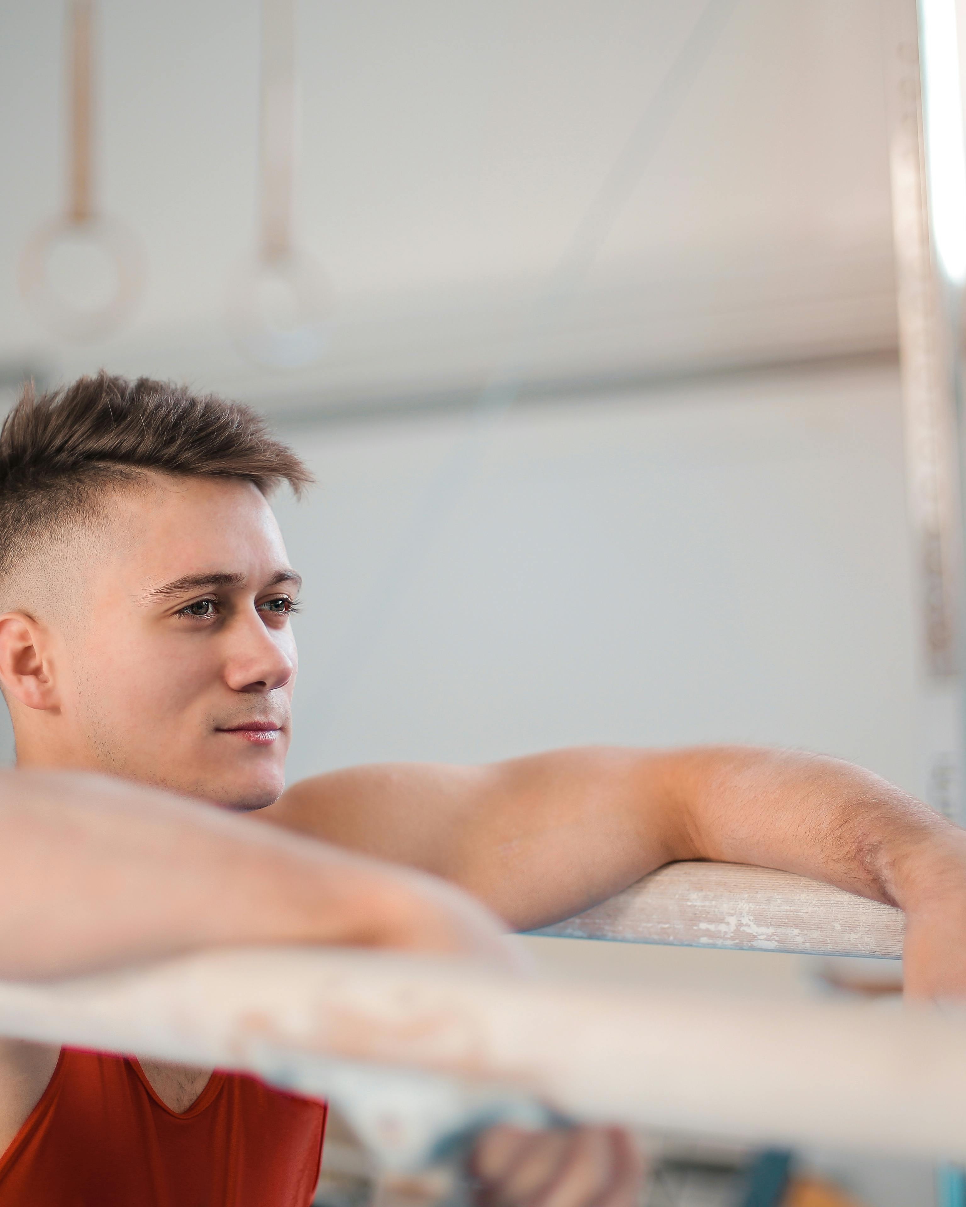 Male Gymnast Resting on Parallel Bars