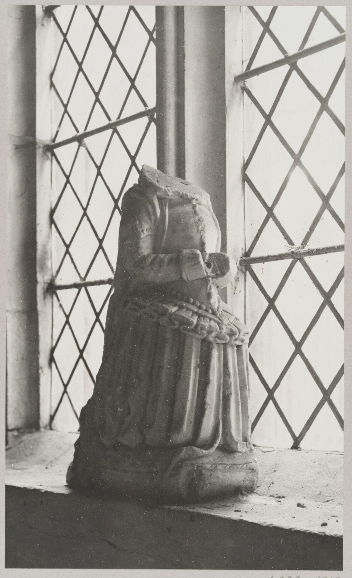 Headless Stone Statue by Lattice Window