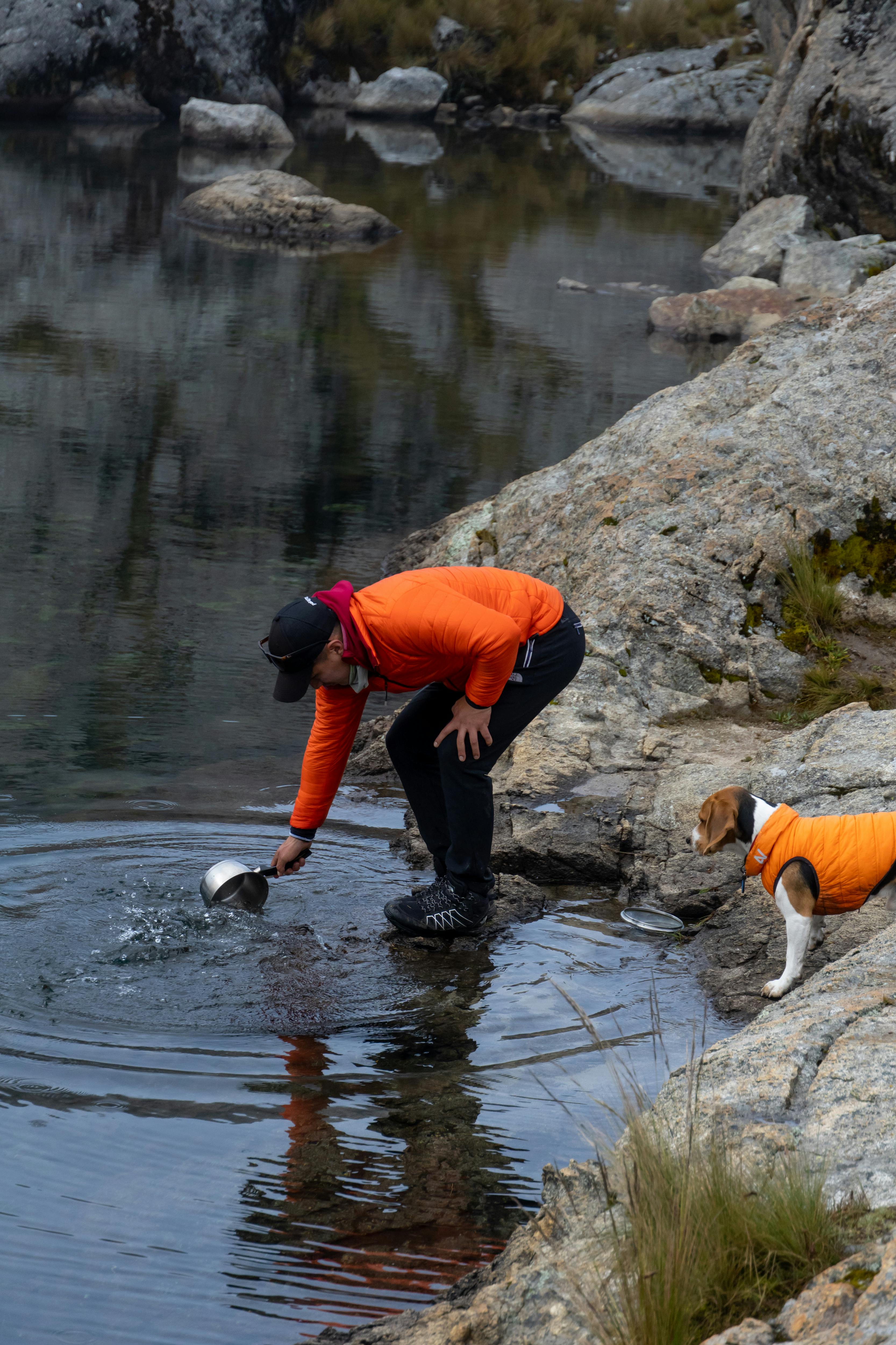 Man and Dog Collect Water at Rocky Lake
