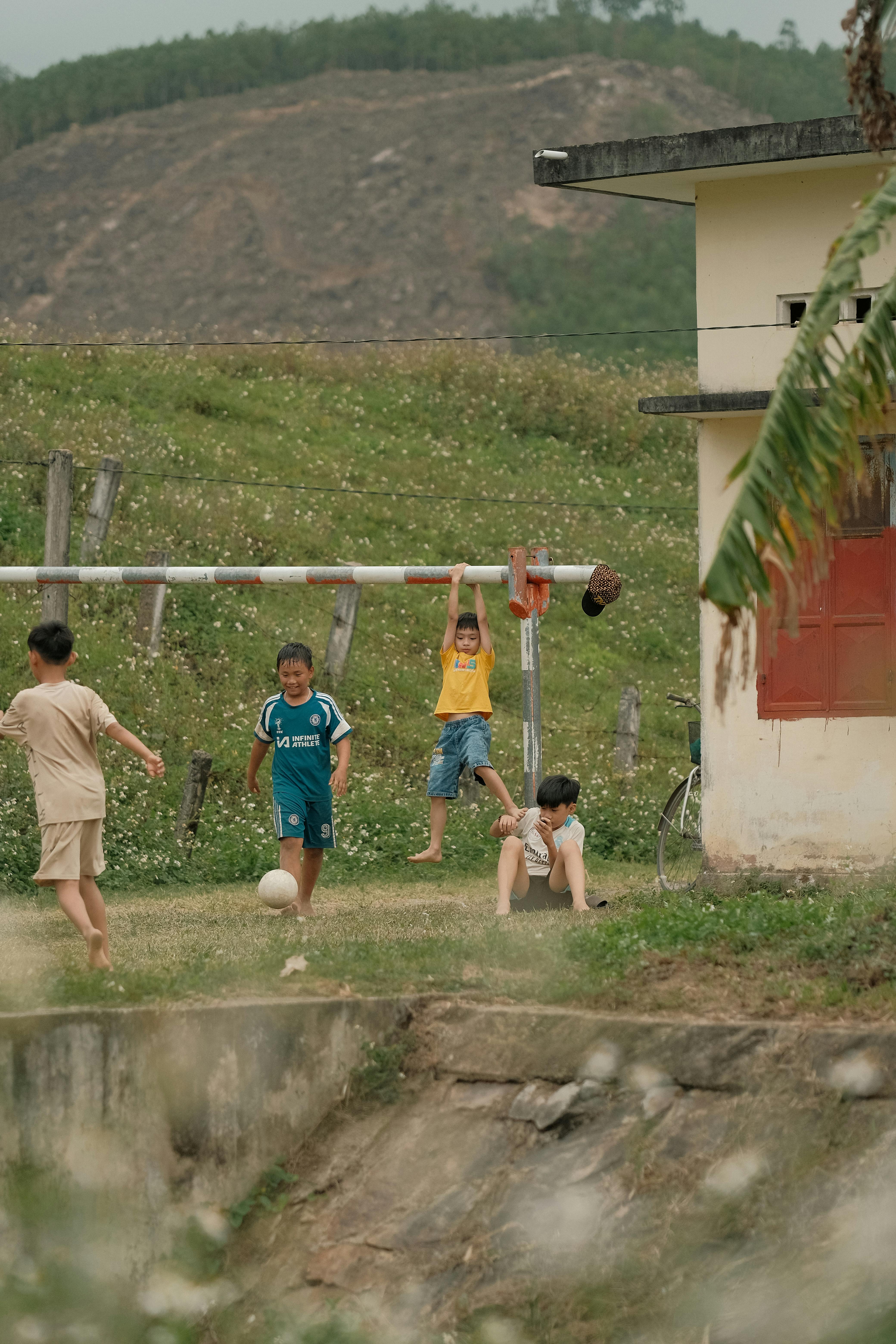 Children Playing Football in Countryside