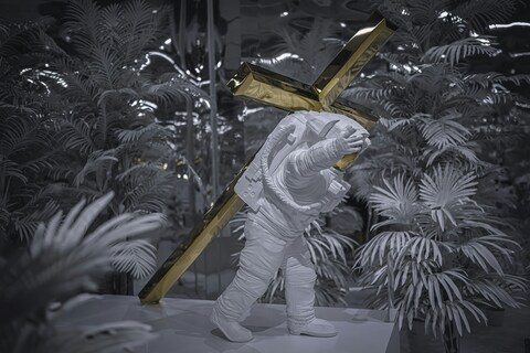 Astronaut Sculpture Carrying Golden Cross