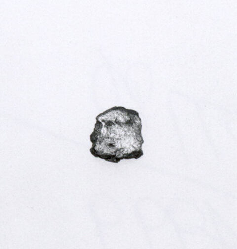 Small Metallic Fragment on White Background