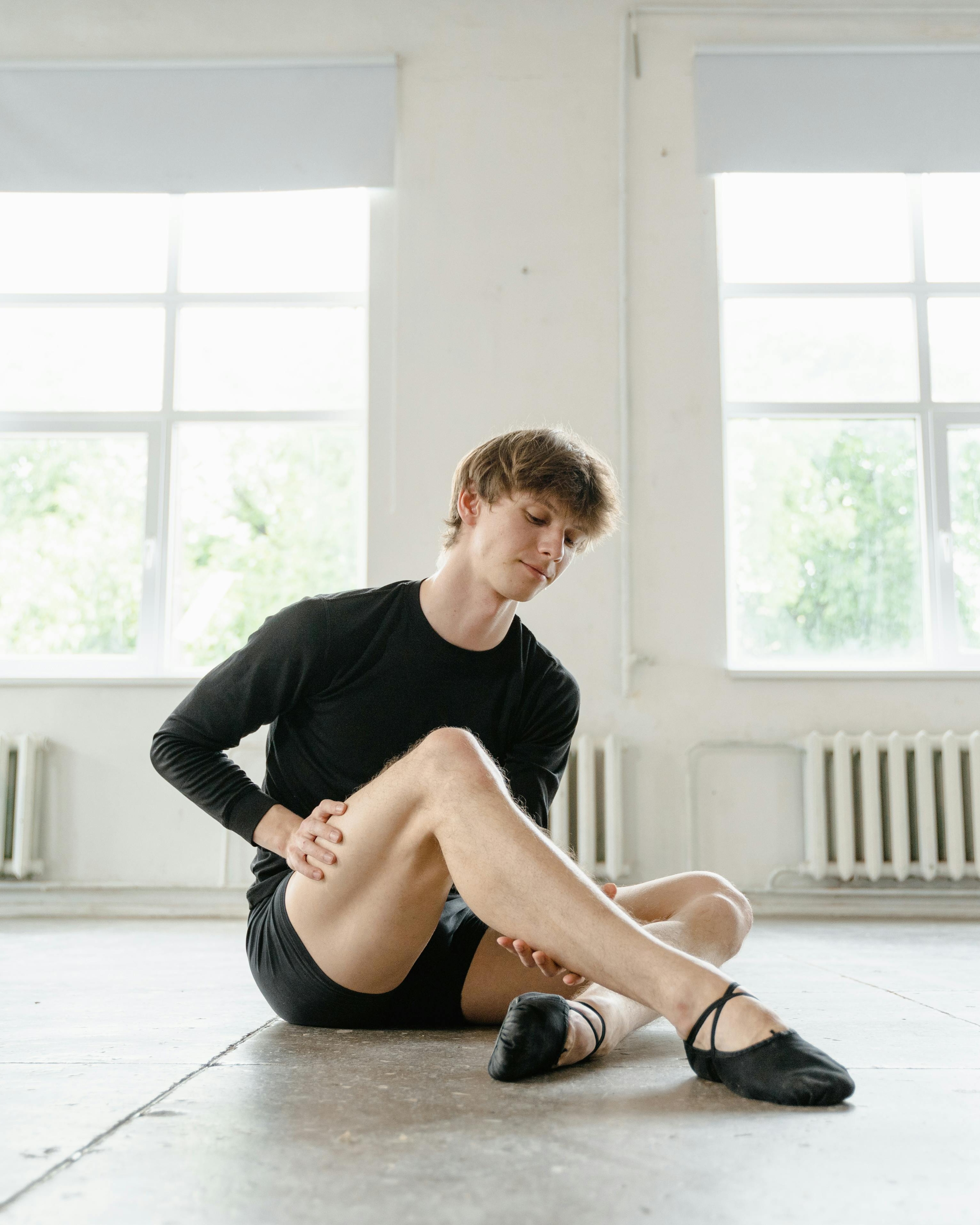 Male Ballet Dancer Stretching in Dance Studio