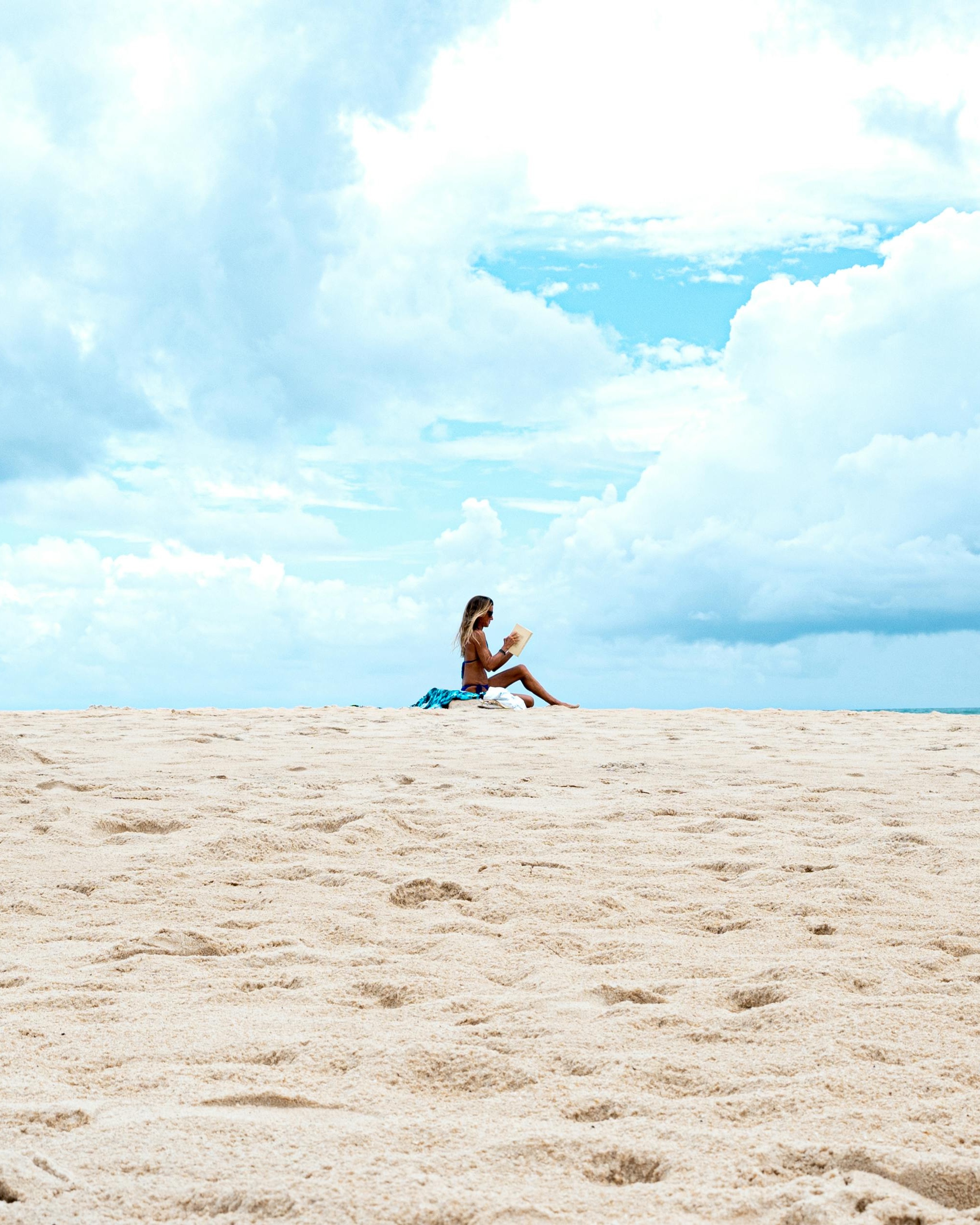 Woman Reading on Empty Beach