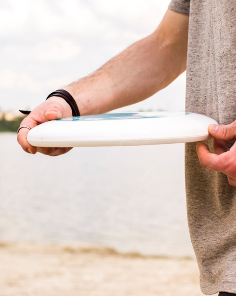 Person Holding Frisbee At Beach