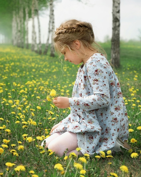 Girl Picking Dandelions in Meadow