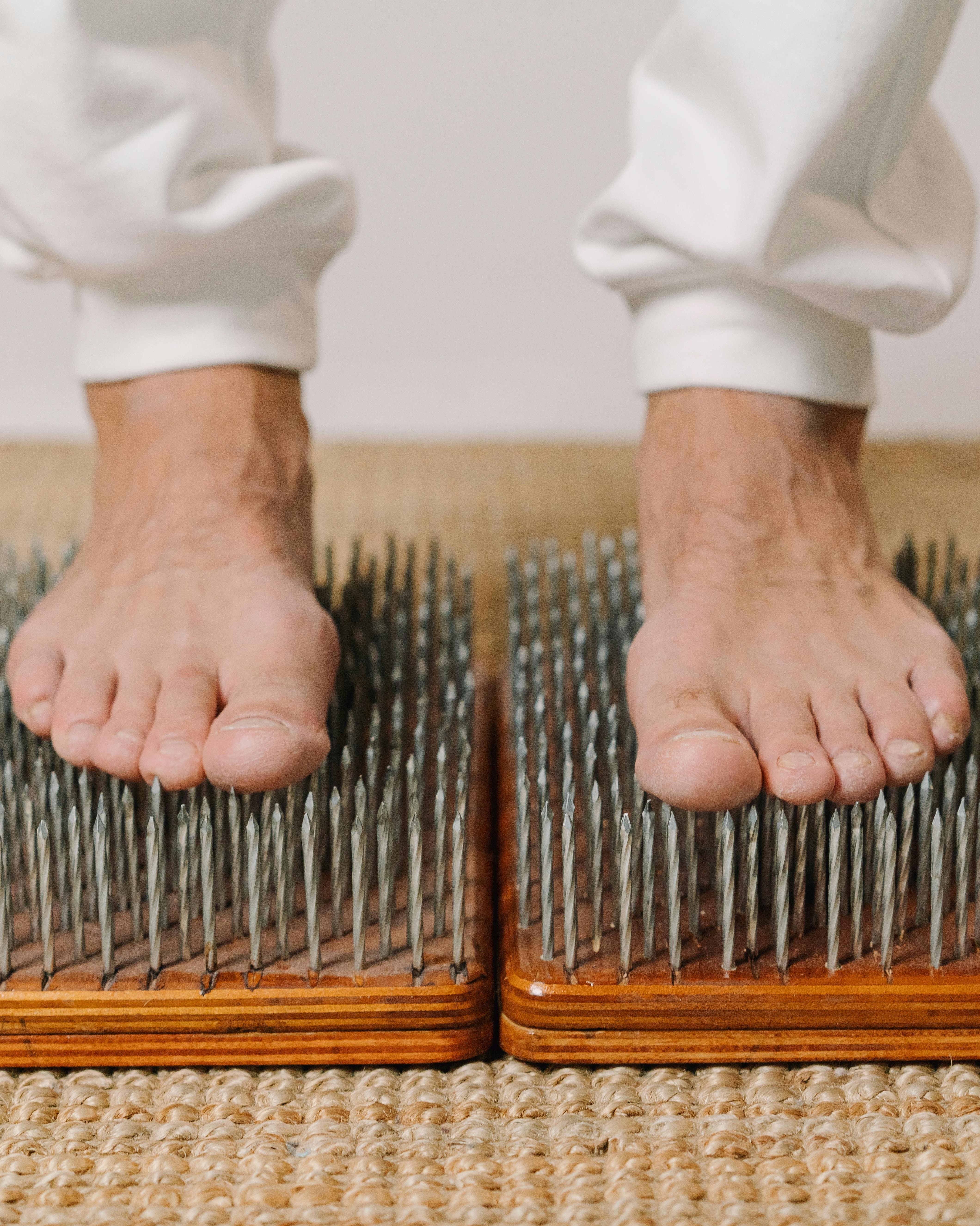 Bare Feet Standing on Nail Boards