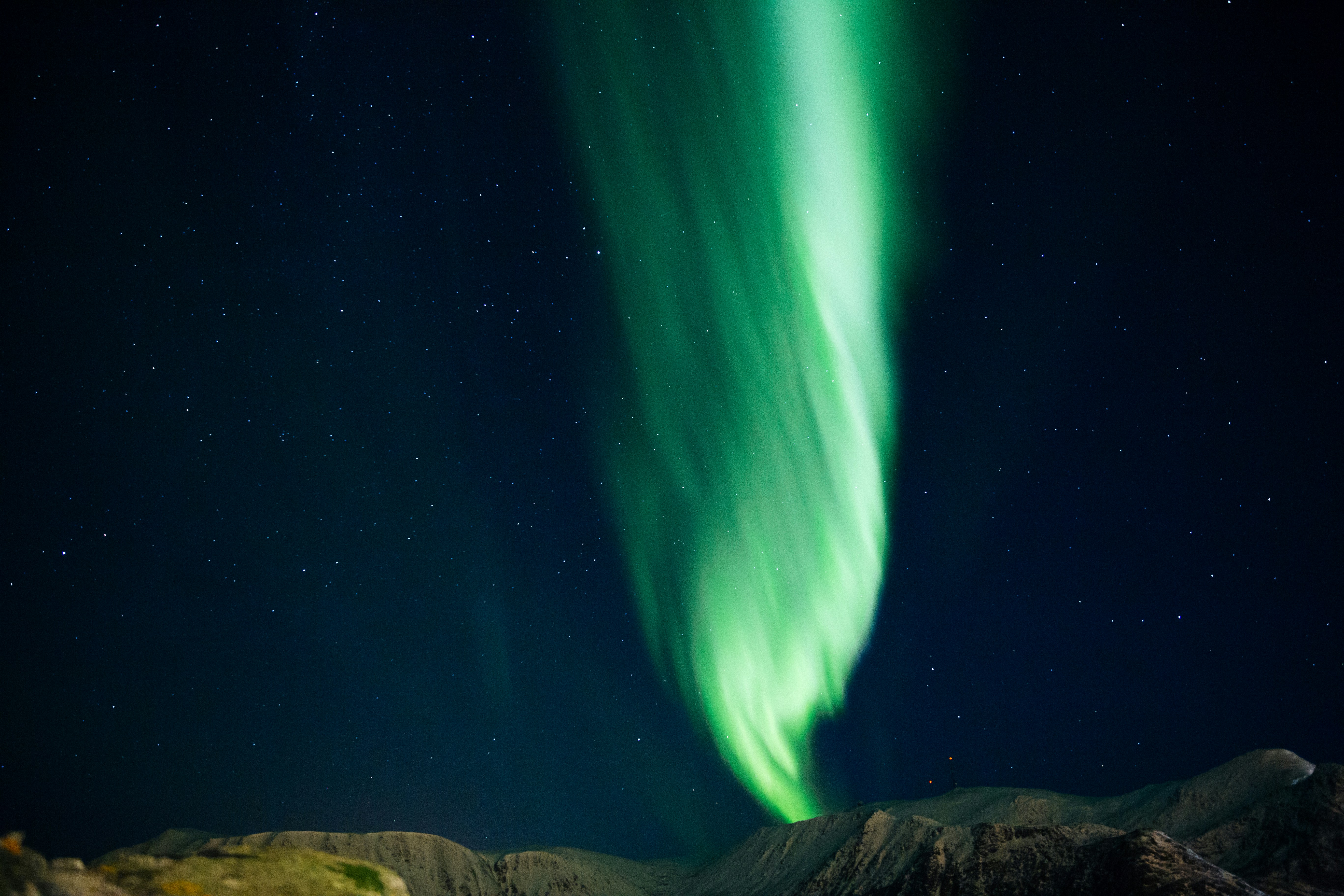 Green Northern Lights Over Snowy Mountains