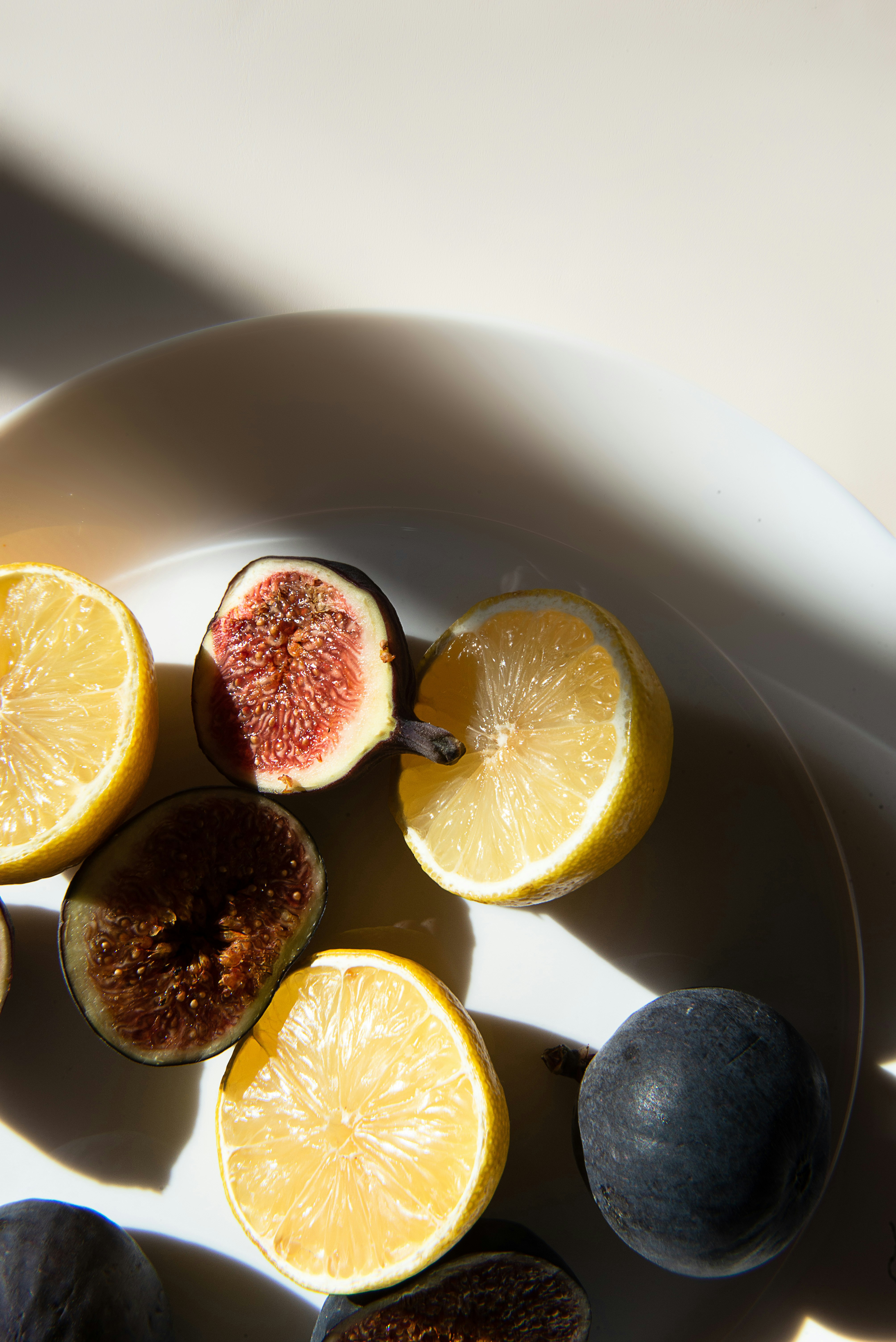 Sliced figs and lemons on plate