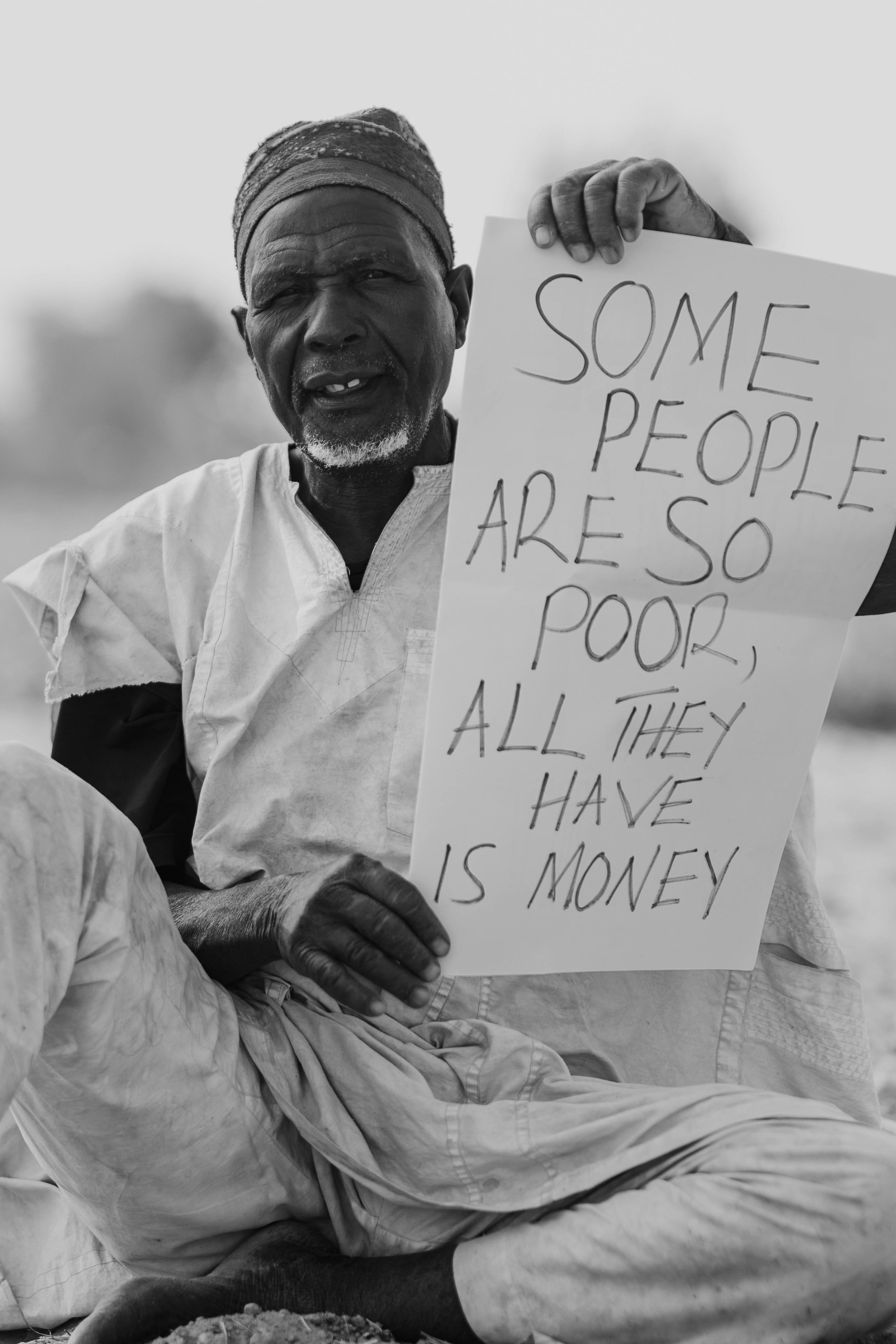Elderly Man Holding Poverty Awareness Sign