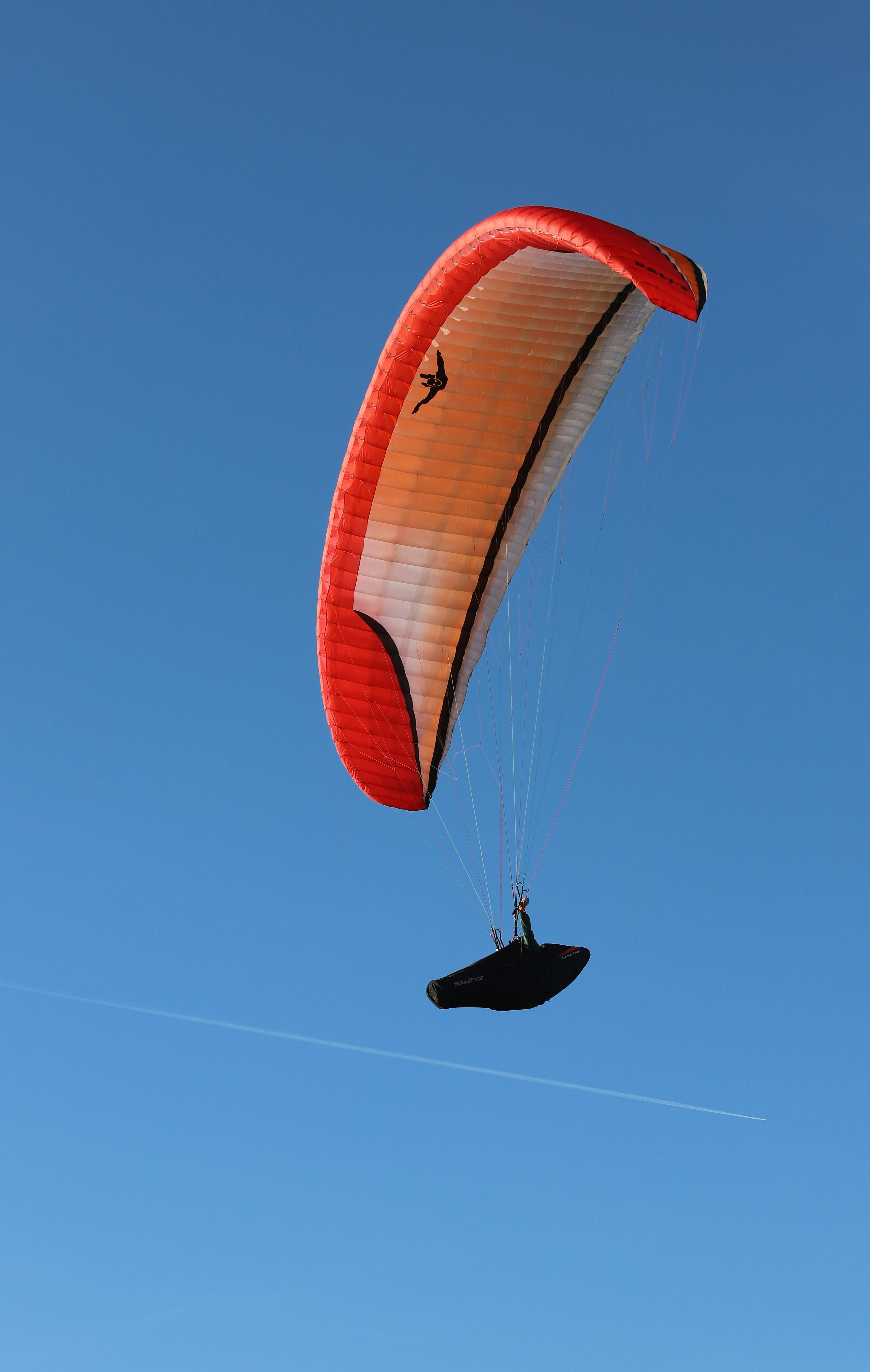 Paraglider Flying In Clear Blue Sky