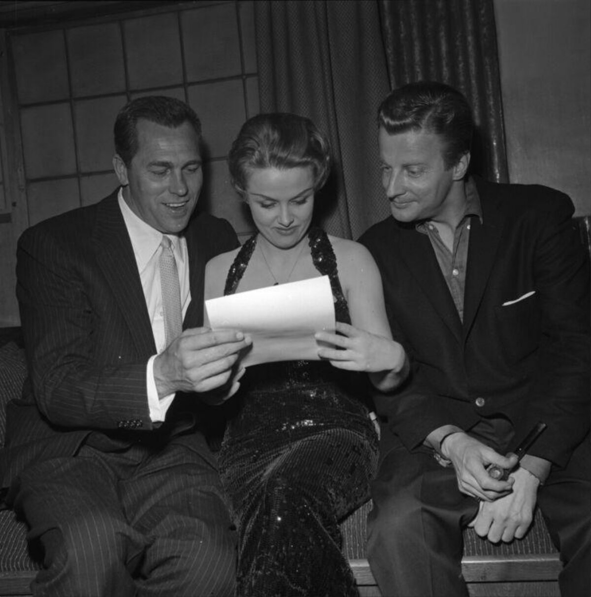 Three People Reading Paper Together