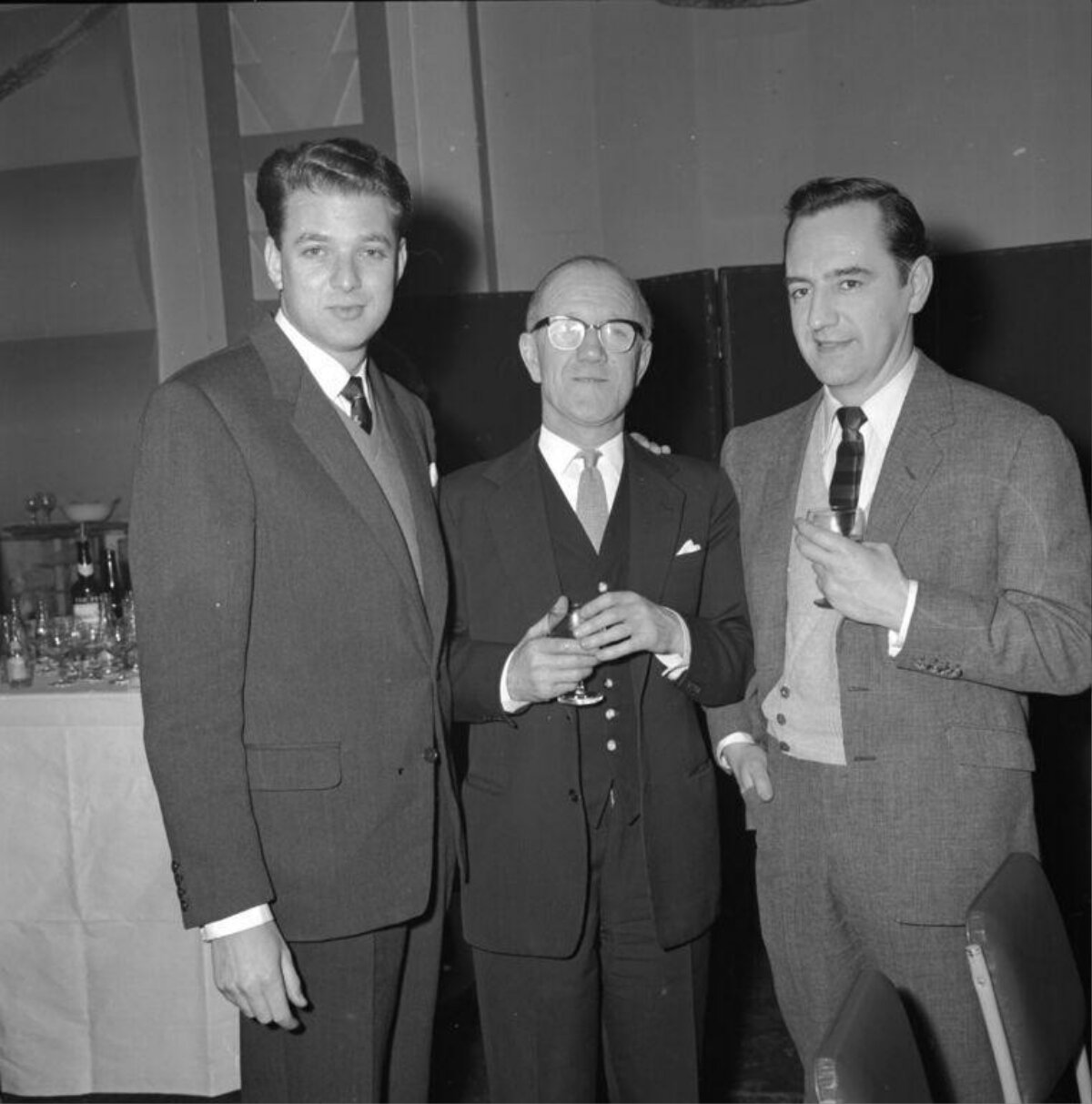 Three Men In Suits At Social Gathering