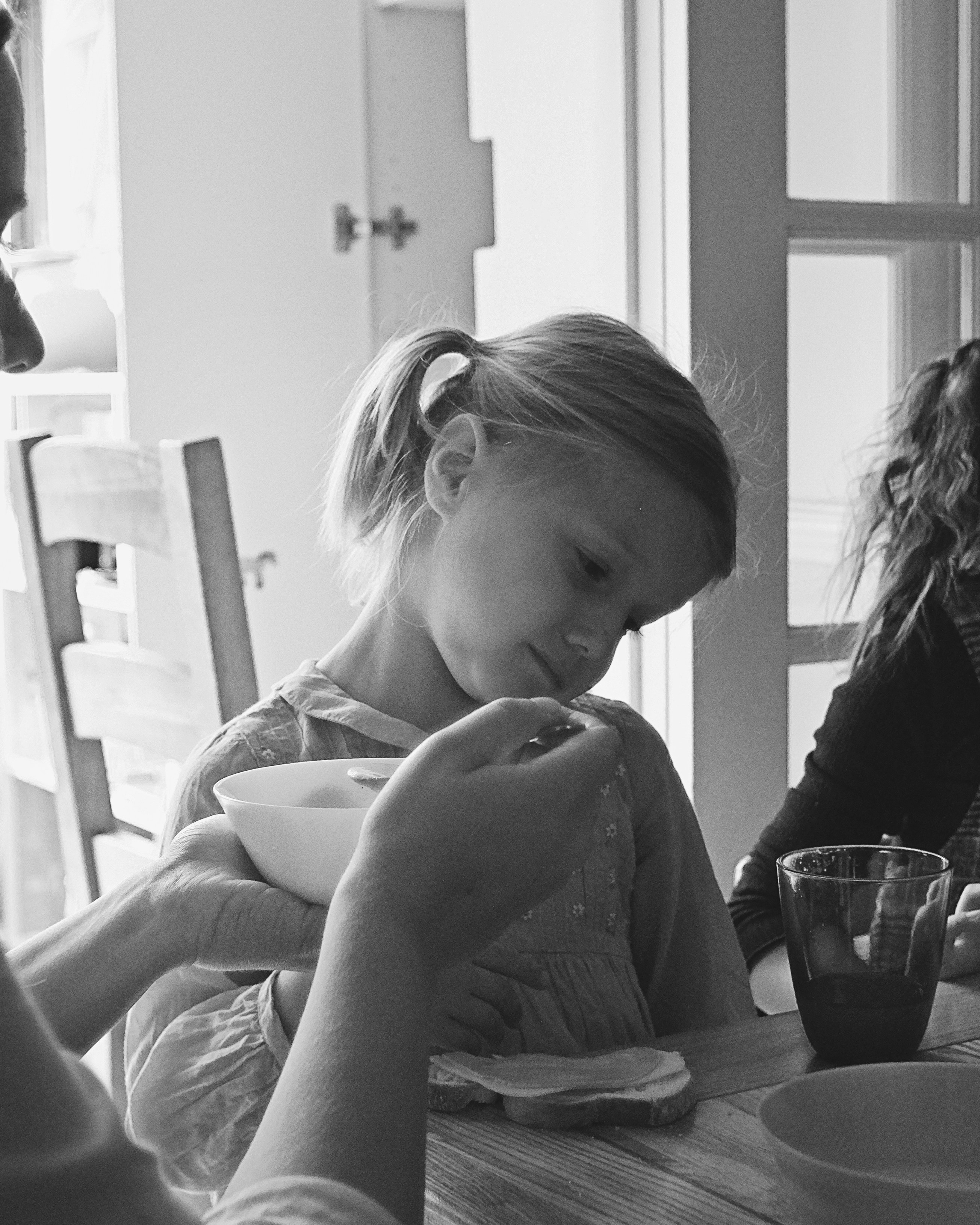 Adult Feeding Young Girl At Mealtime