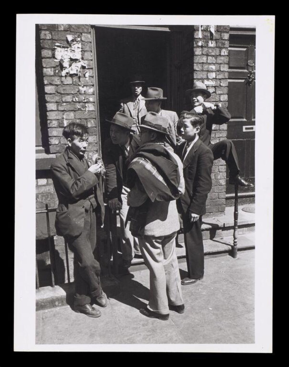 Group of Men Gathered at Brick Doorway
