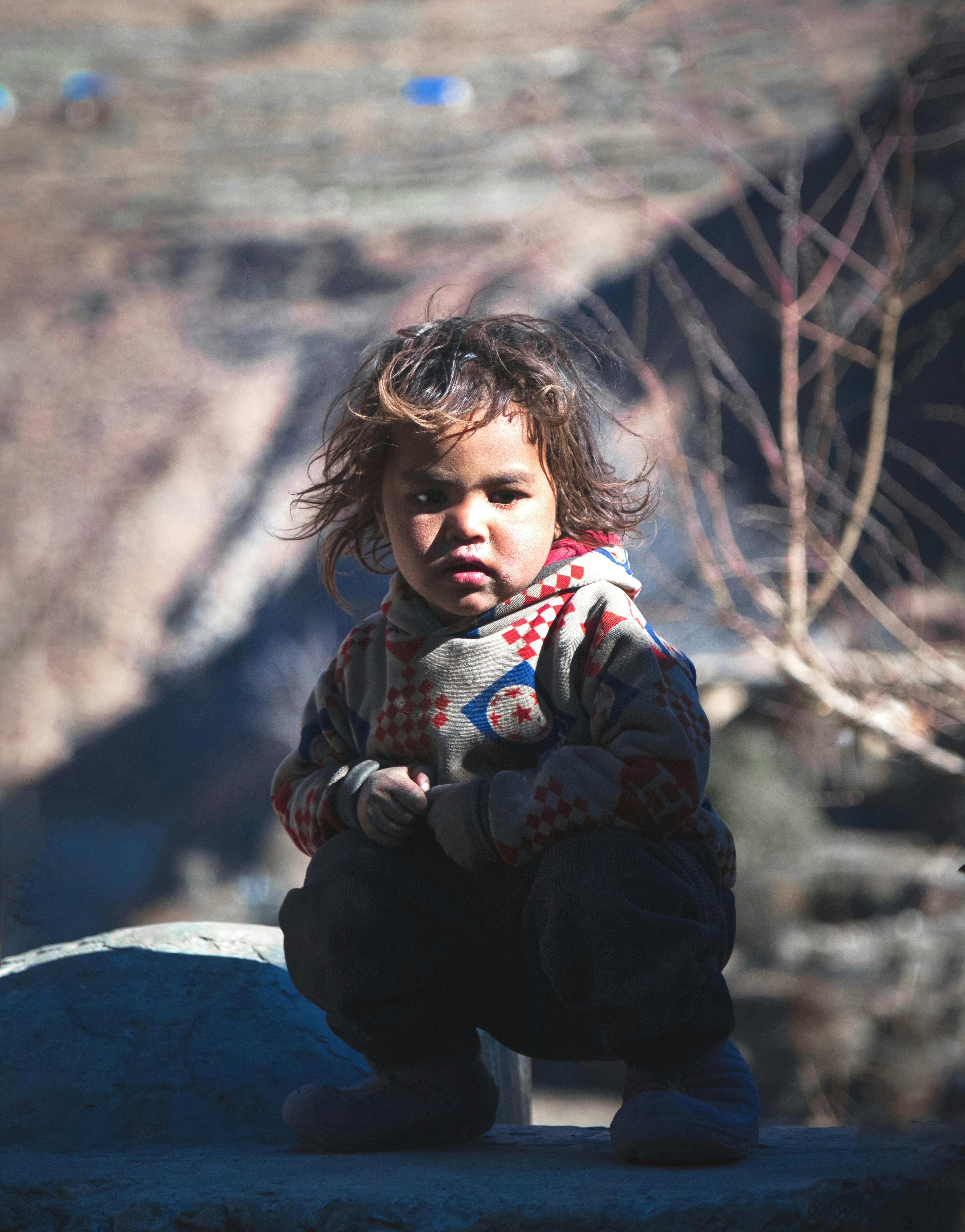 Crouching Child in Mountain Area