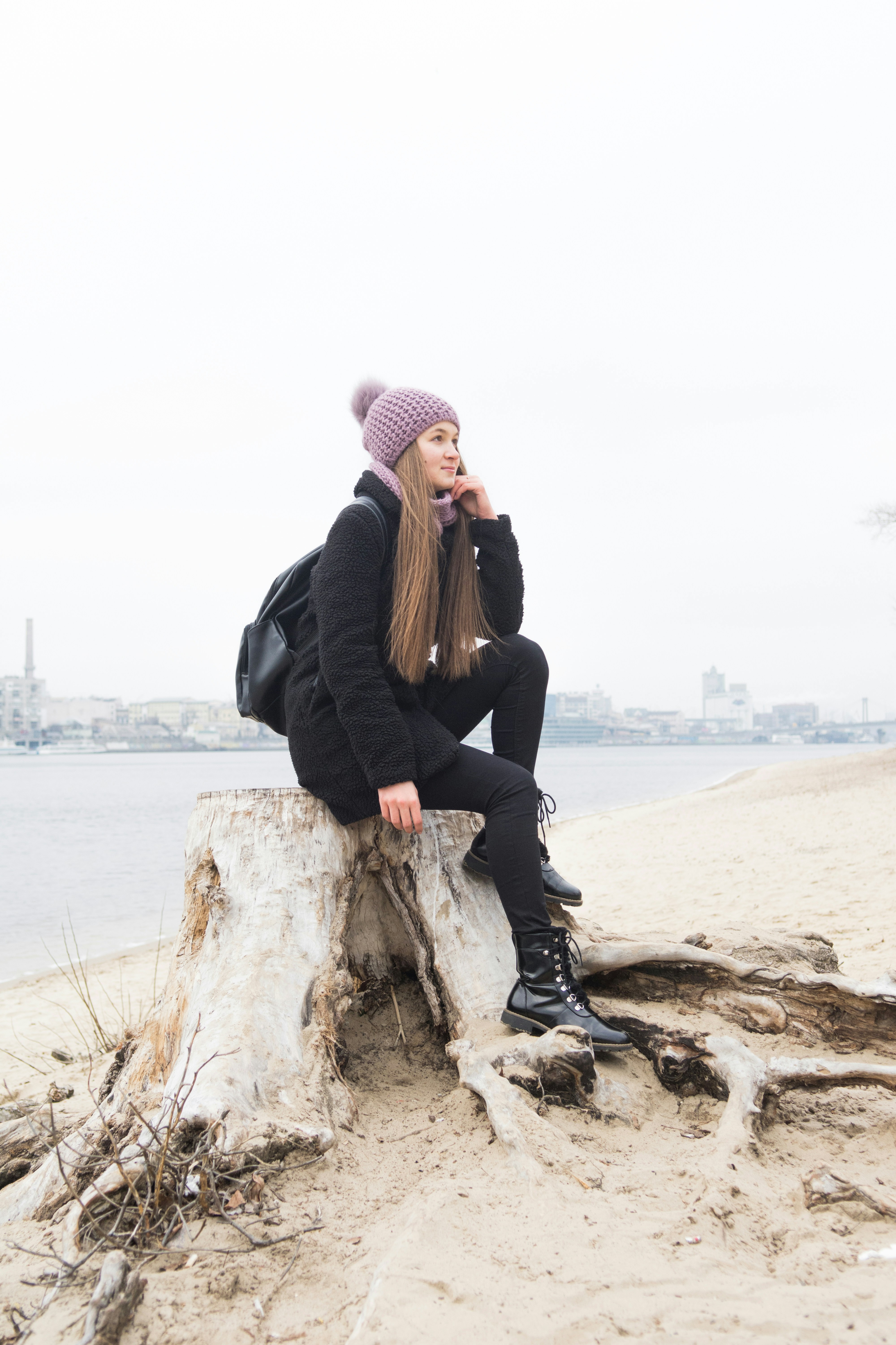 Young Woman on Tree Stump by River