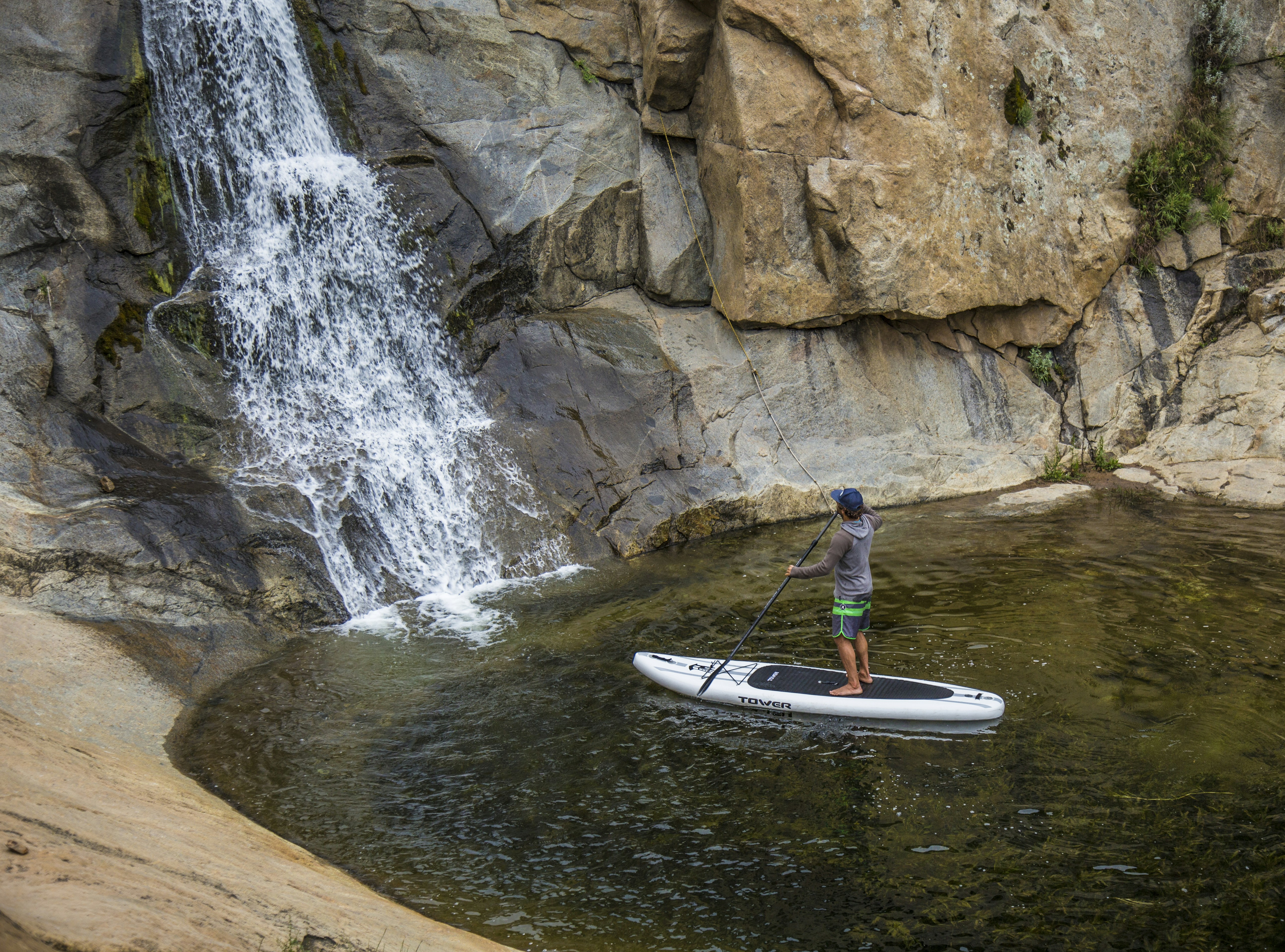 Stand Up Paddler by Waterfall Pool
