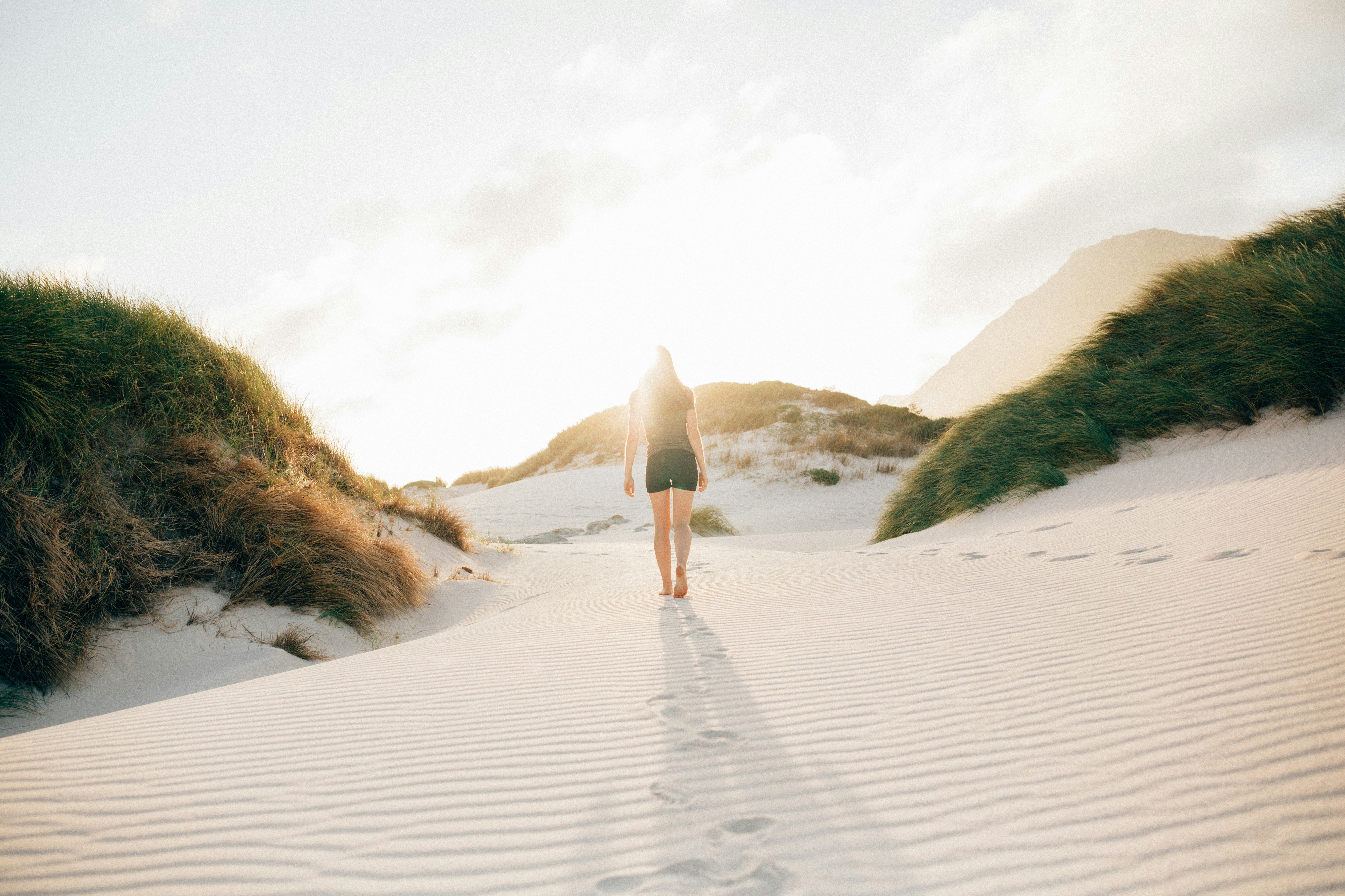 Woman Walking Through Sand Dunes