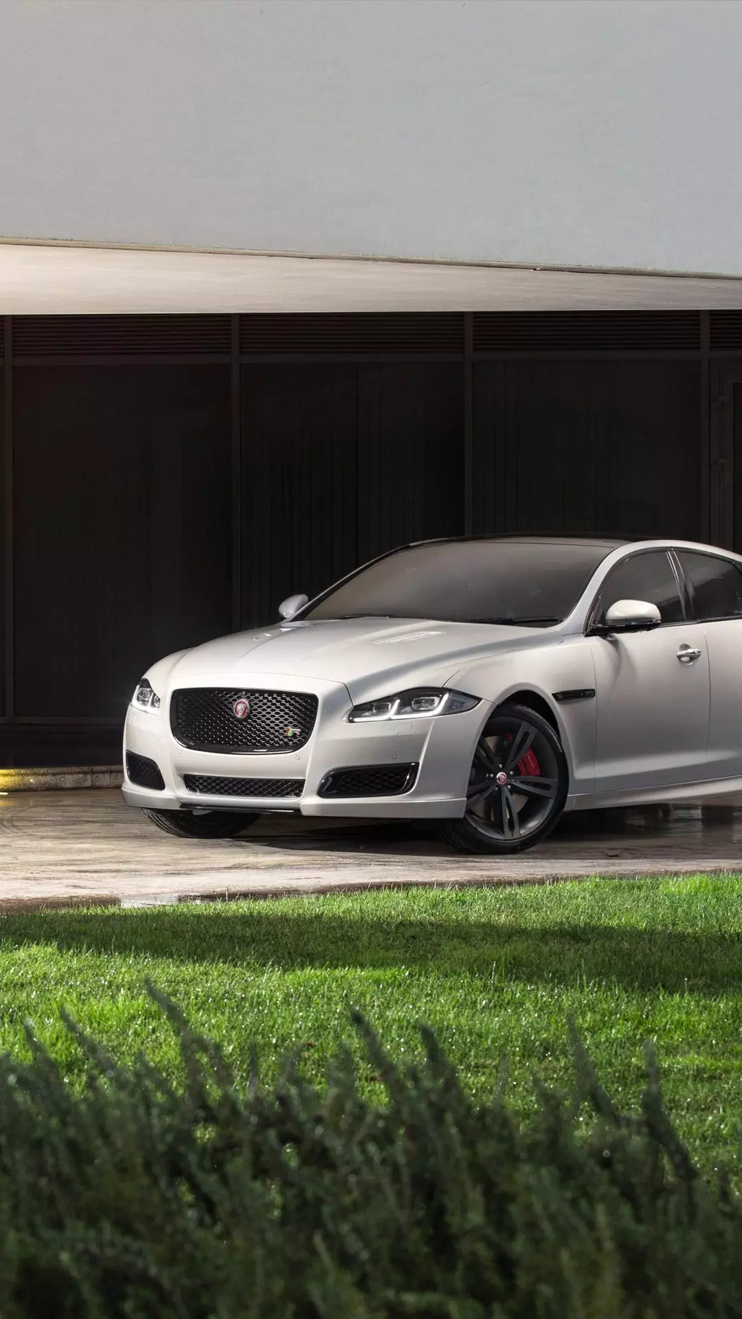 Silver Jaguar Sedan Parked Outside Modern Building