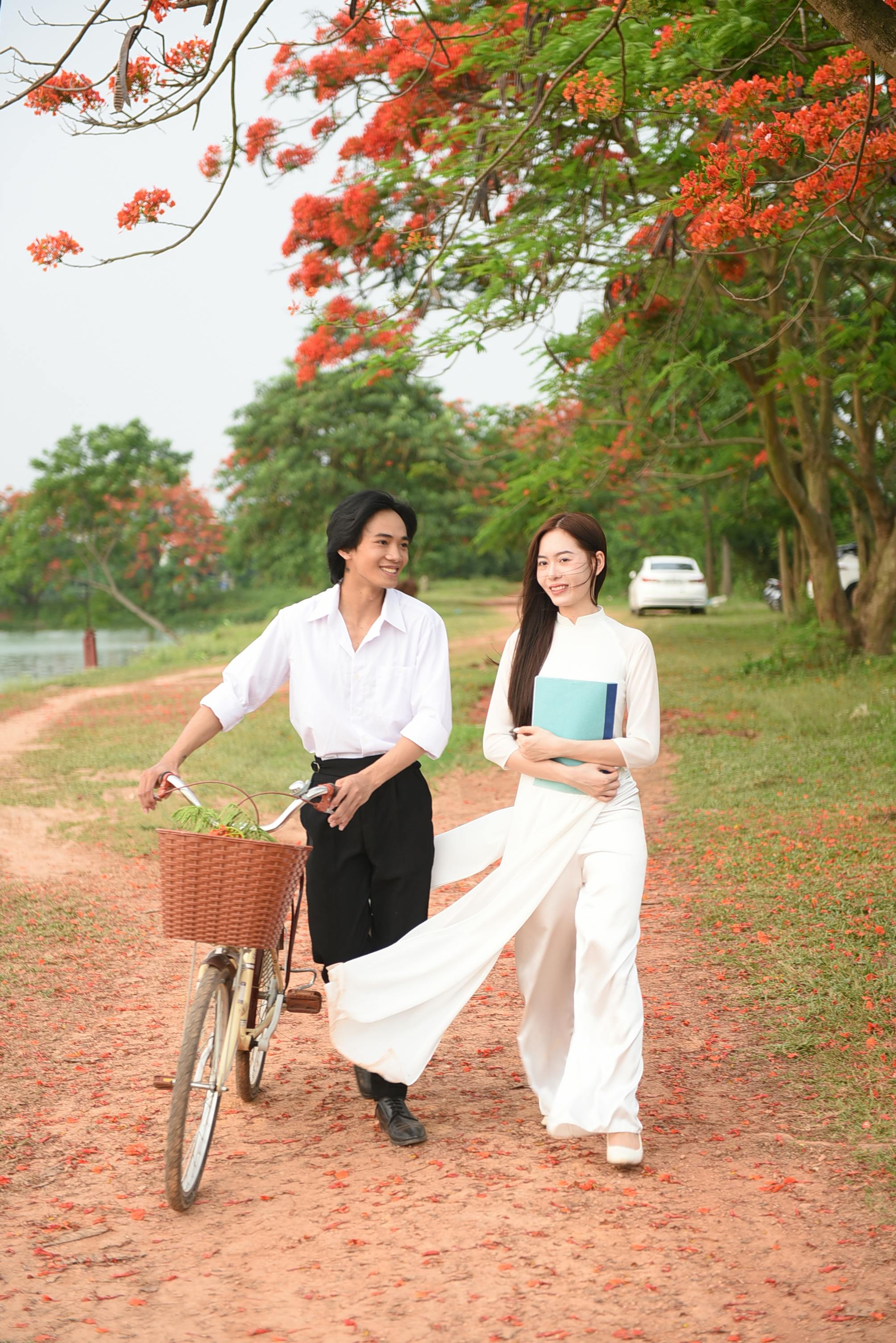 Young Couple Walking Under Red Flowering Trees