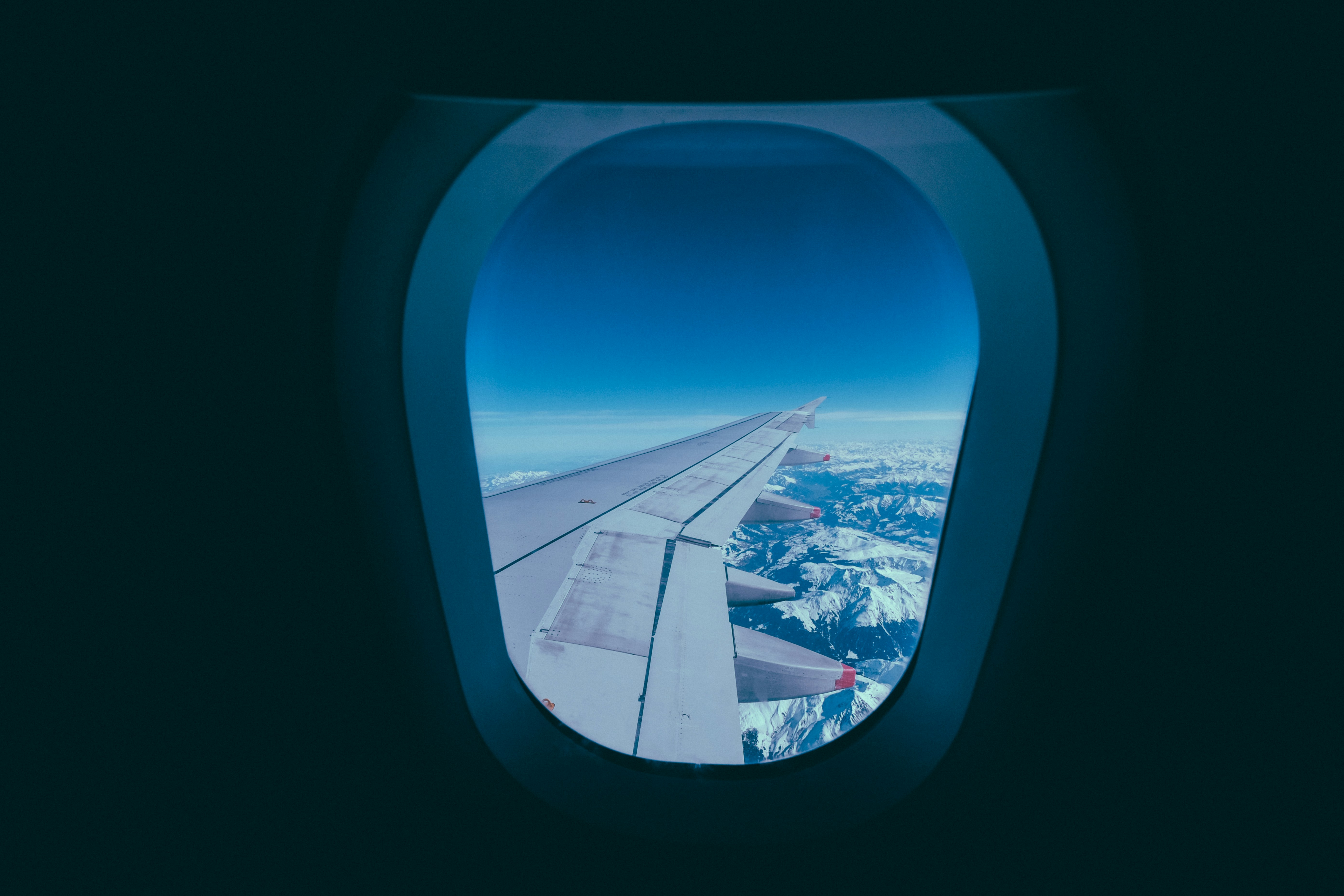 Airplane Wing View Over Snowy Mountains