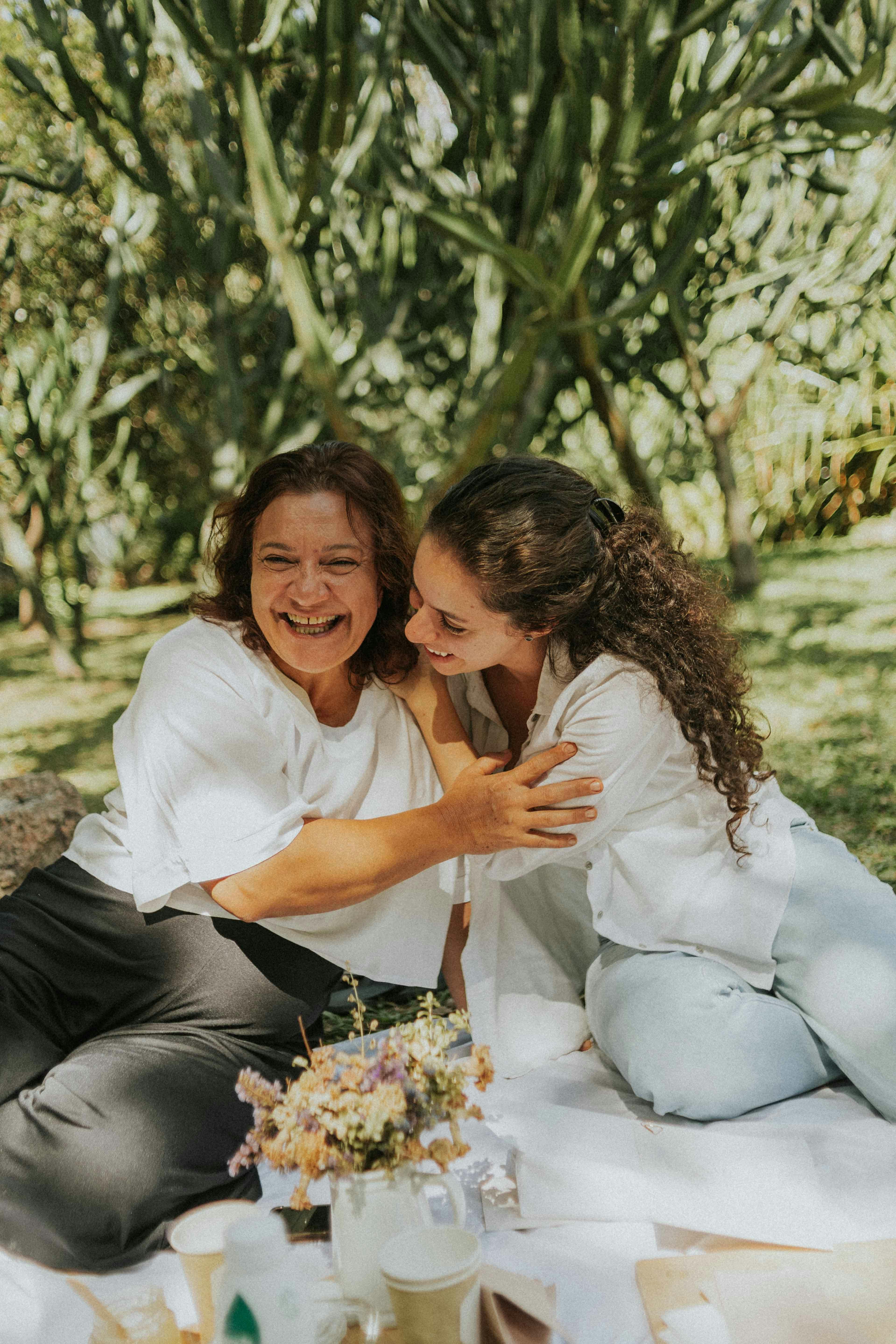 Two Women Laughing On Outdoor Picnic
