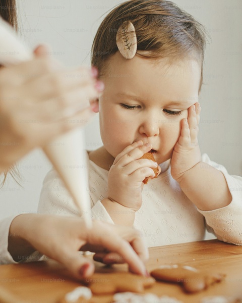Toddler Eats Cookie During Gingerbread Decorating