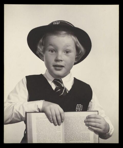 Young Schoolboy Holding Open Book