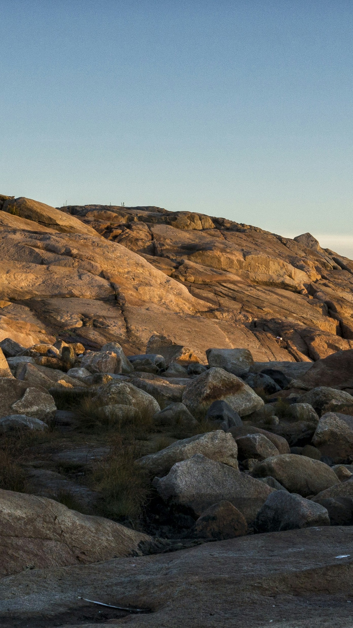 Sunlit Rocky Hillside Under Clear Sky